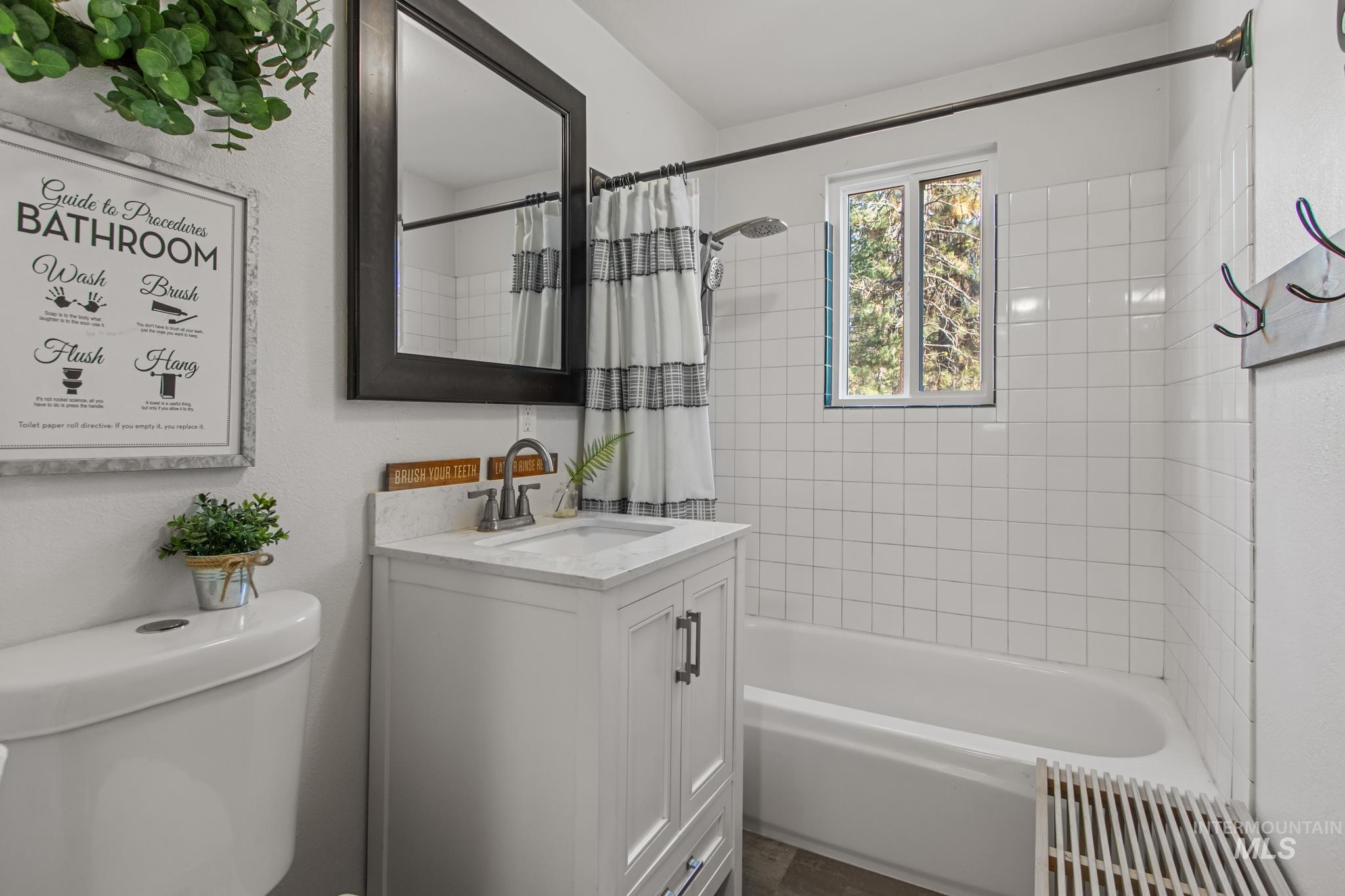 Full bathroom featuring shower / bathtub combination with curtain and vanity