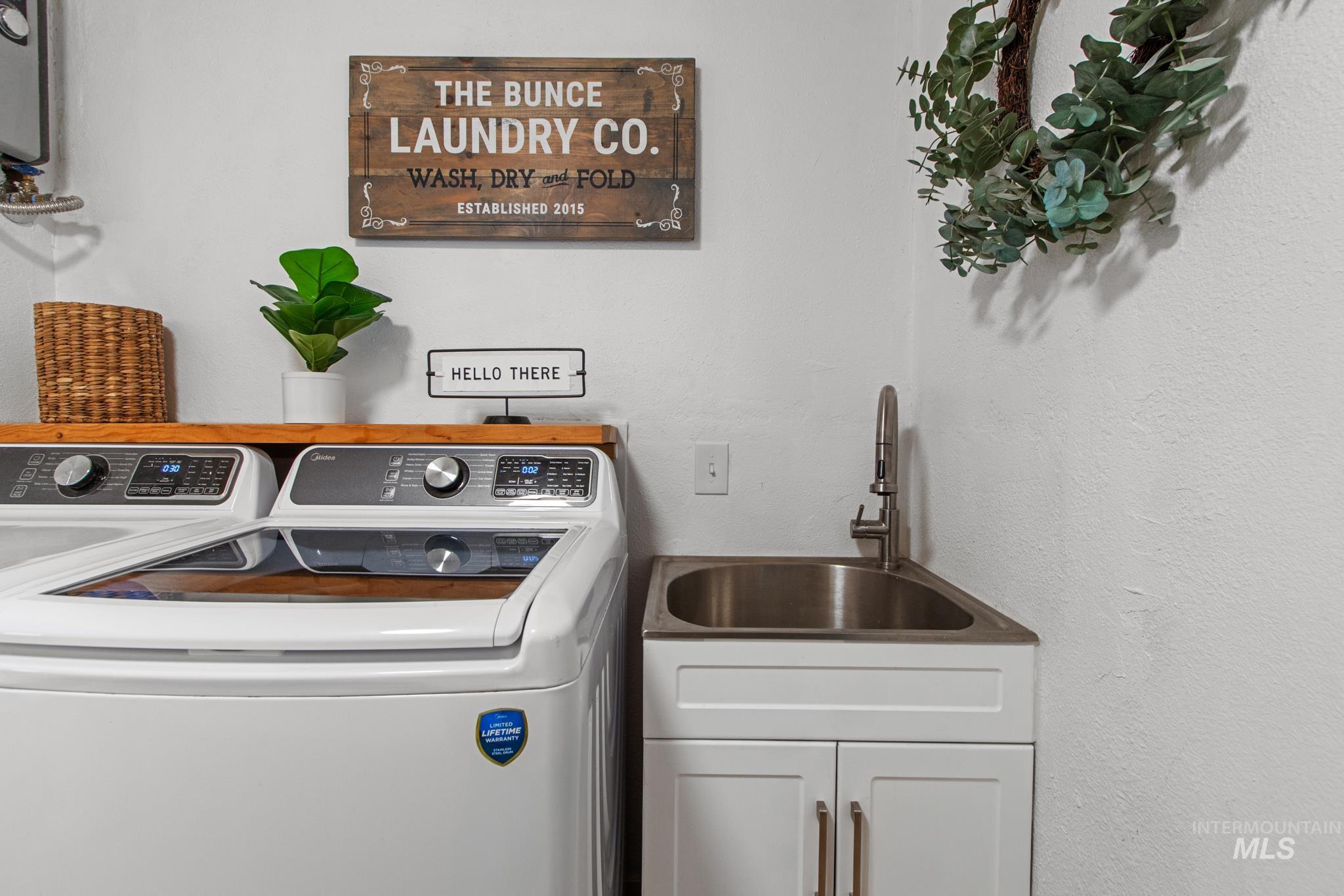 Laundry room with washing machine and dryer and a textured wall