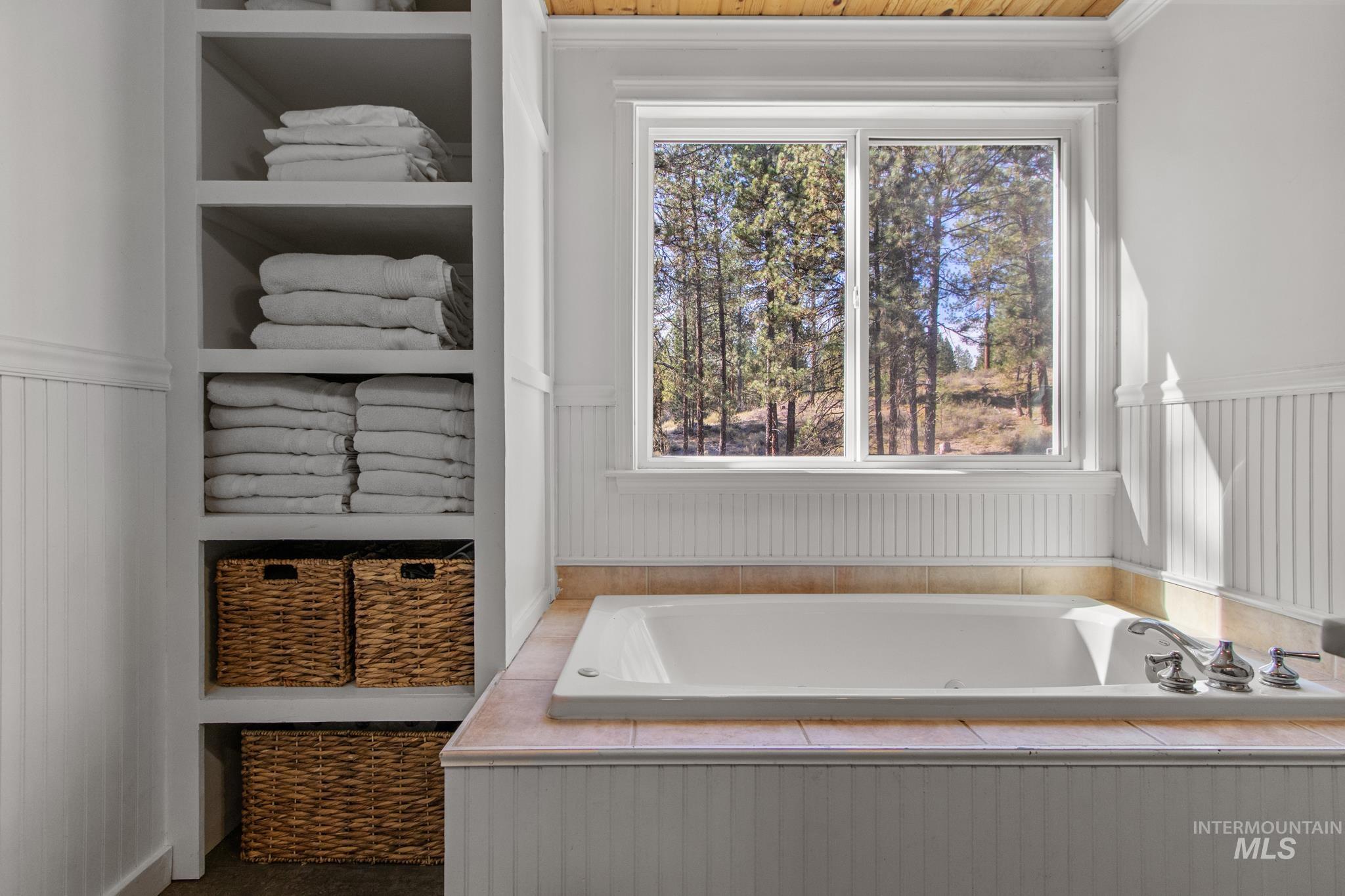 Full bath with a garden tub and wainscoting