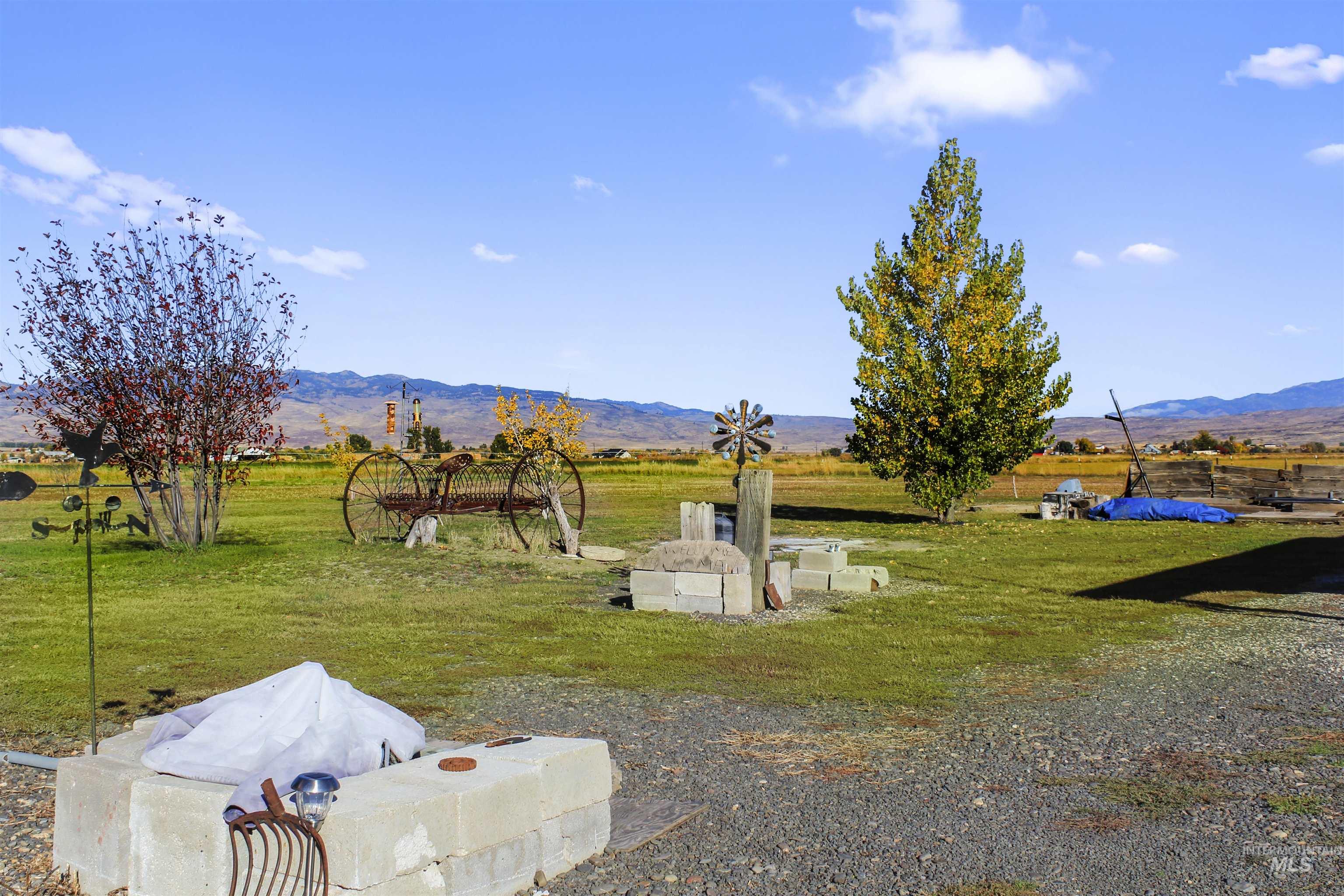 View of green lawn with a rural view and a mountain view