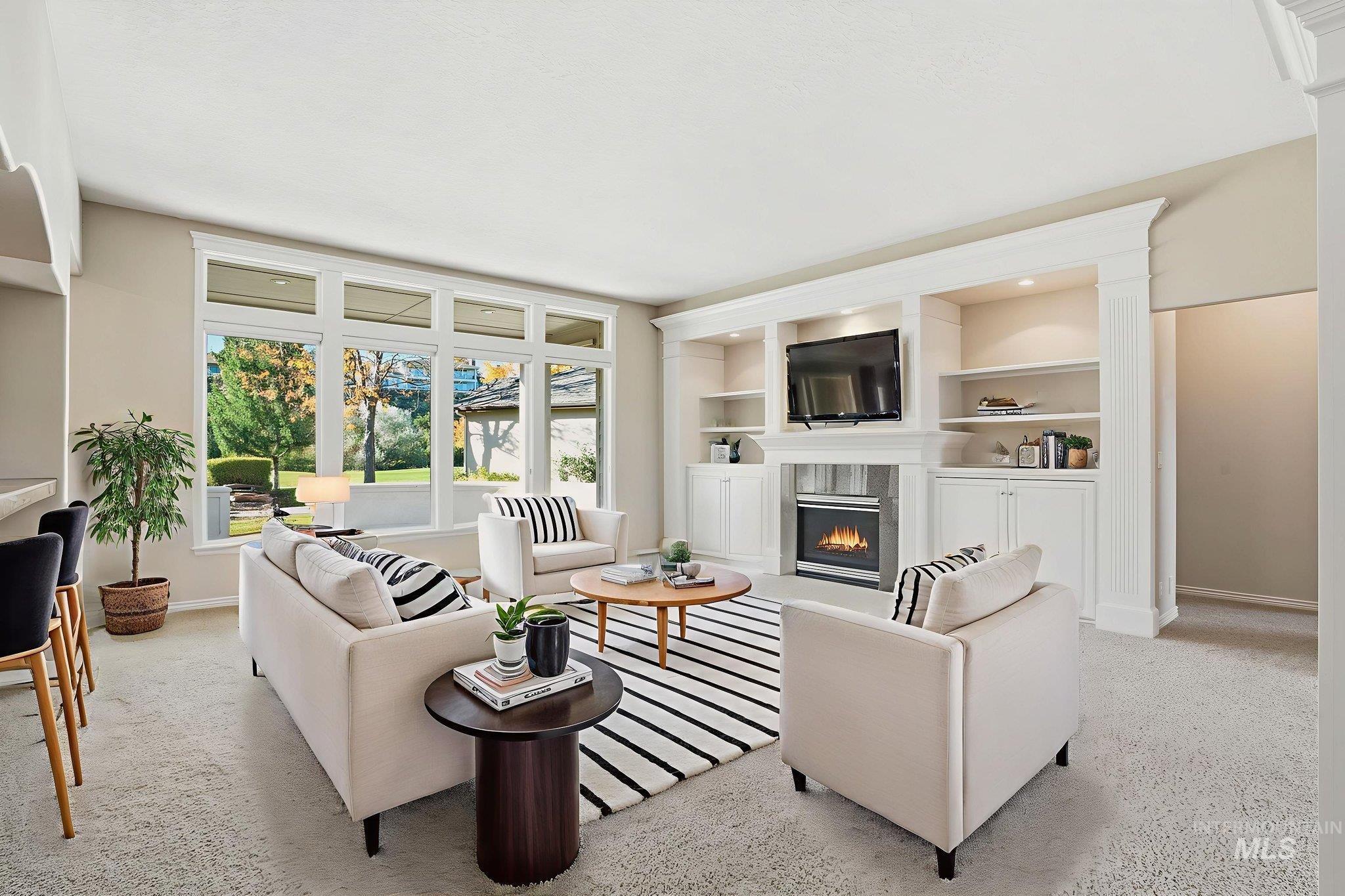 Living room with a glass covered fireplace and light colored carpet