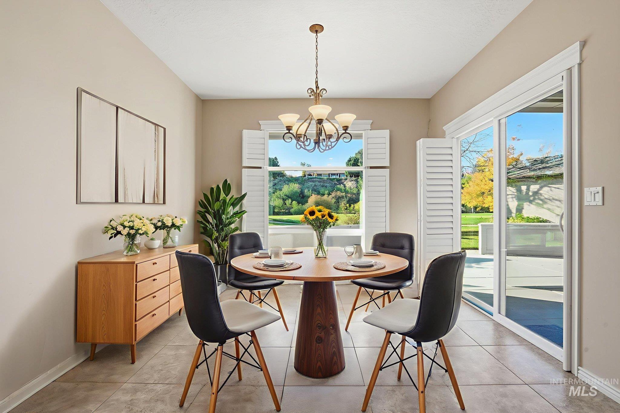 Dining area featuring light tile patterned flooring and a chandelier - virtual staged