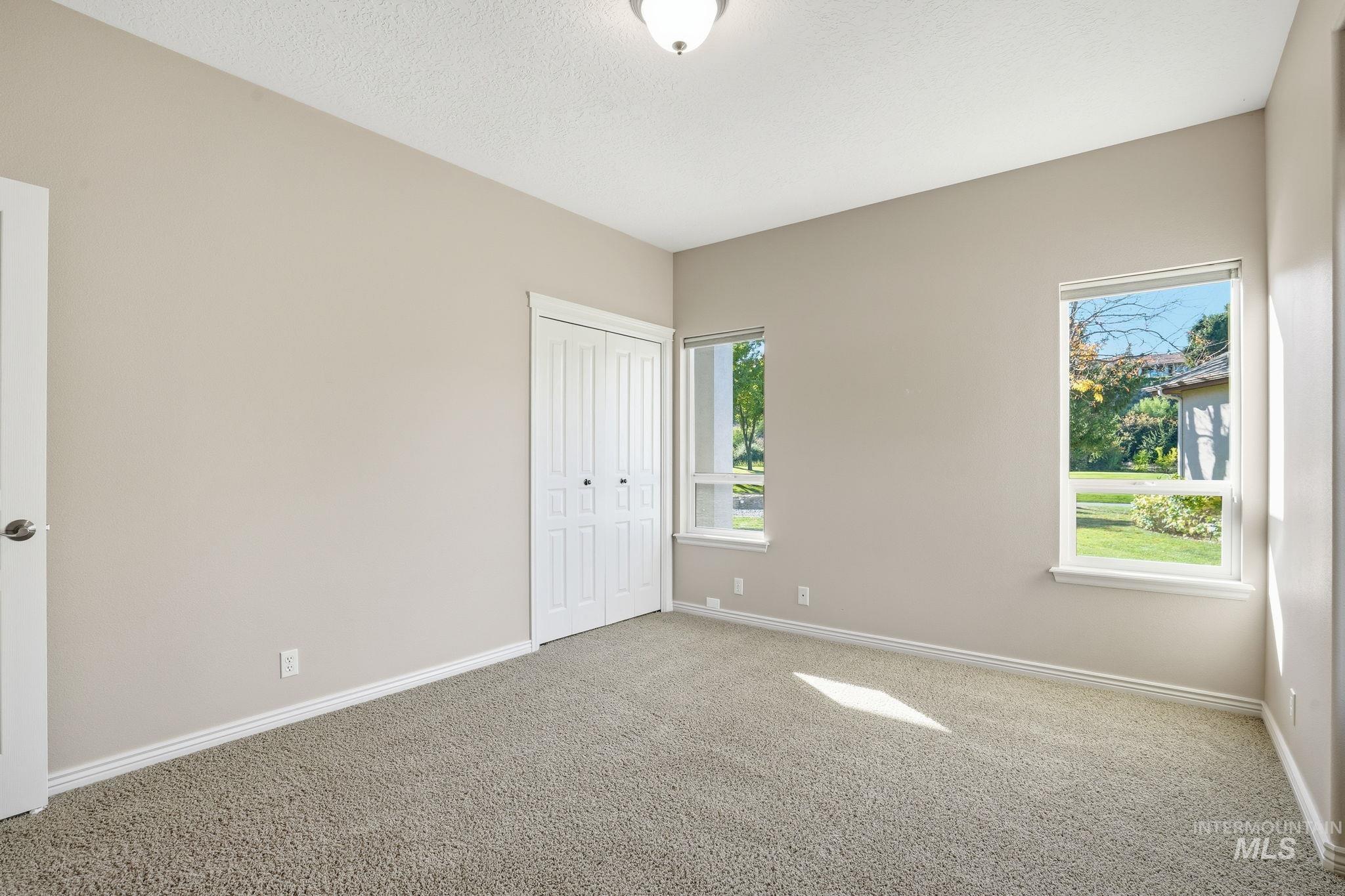 Unfurnished bedroom with carpet, a closet, and a textured ceiling