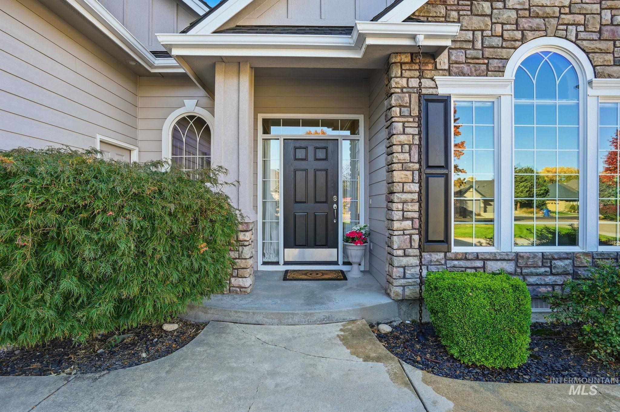 Doorway to property featuring stone siding and board and batten siding