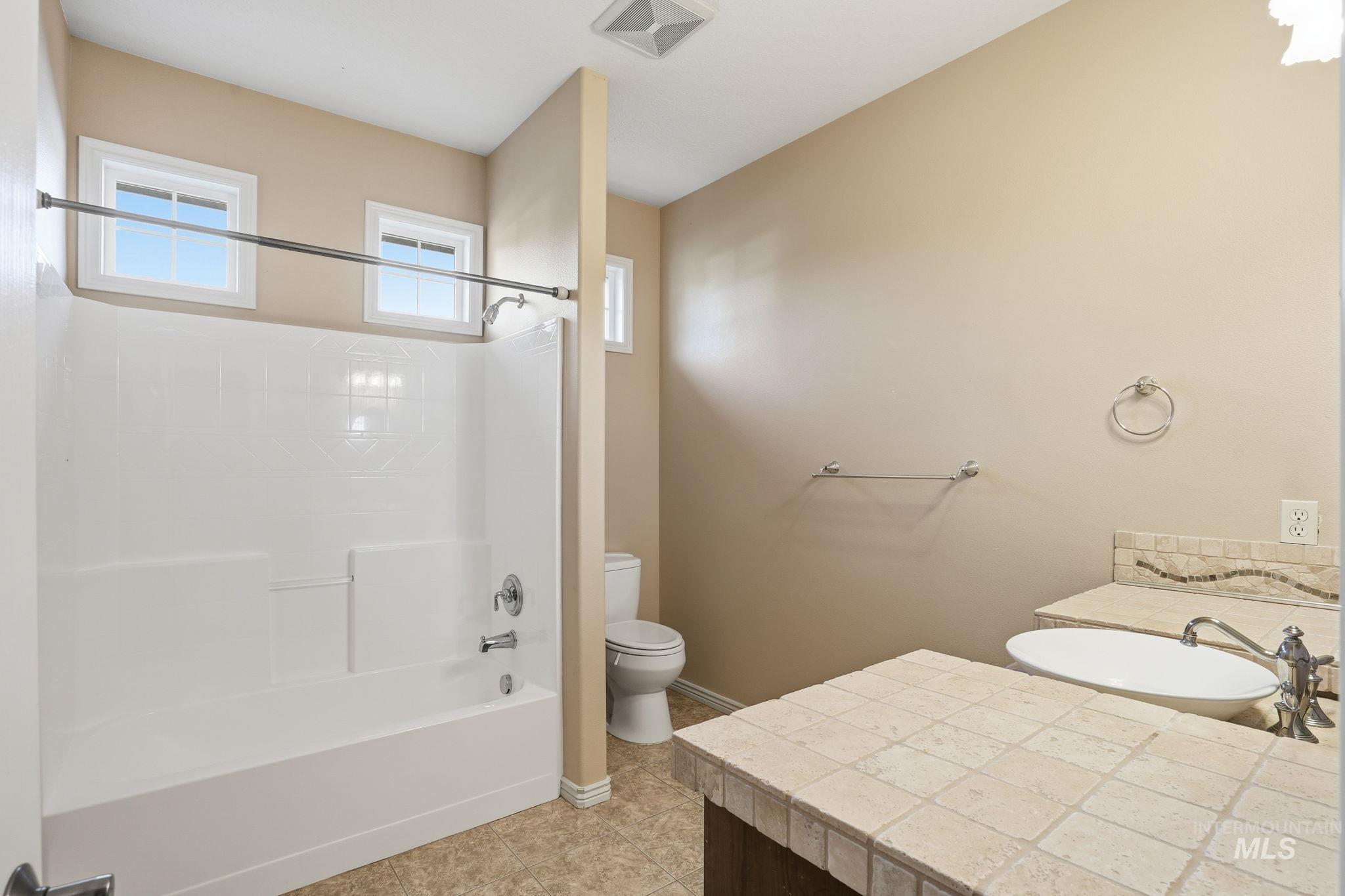 Bathroom featuring vanity,  shower combination, and light tile patterned floors