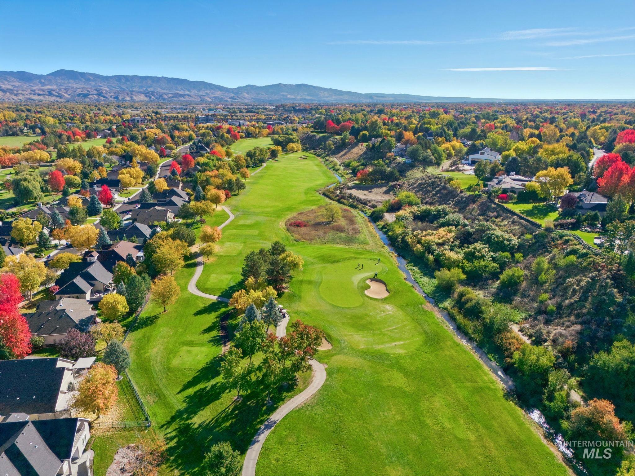 Aerial view of residential area featuring a golf club and a mountain backdrop