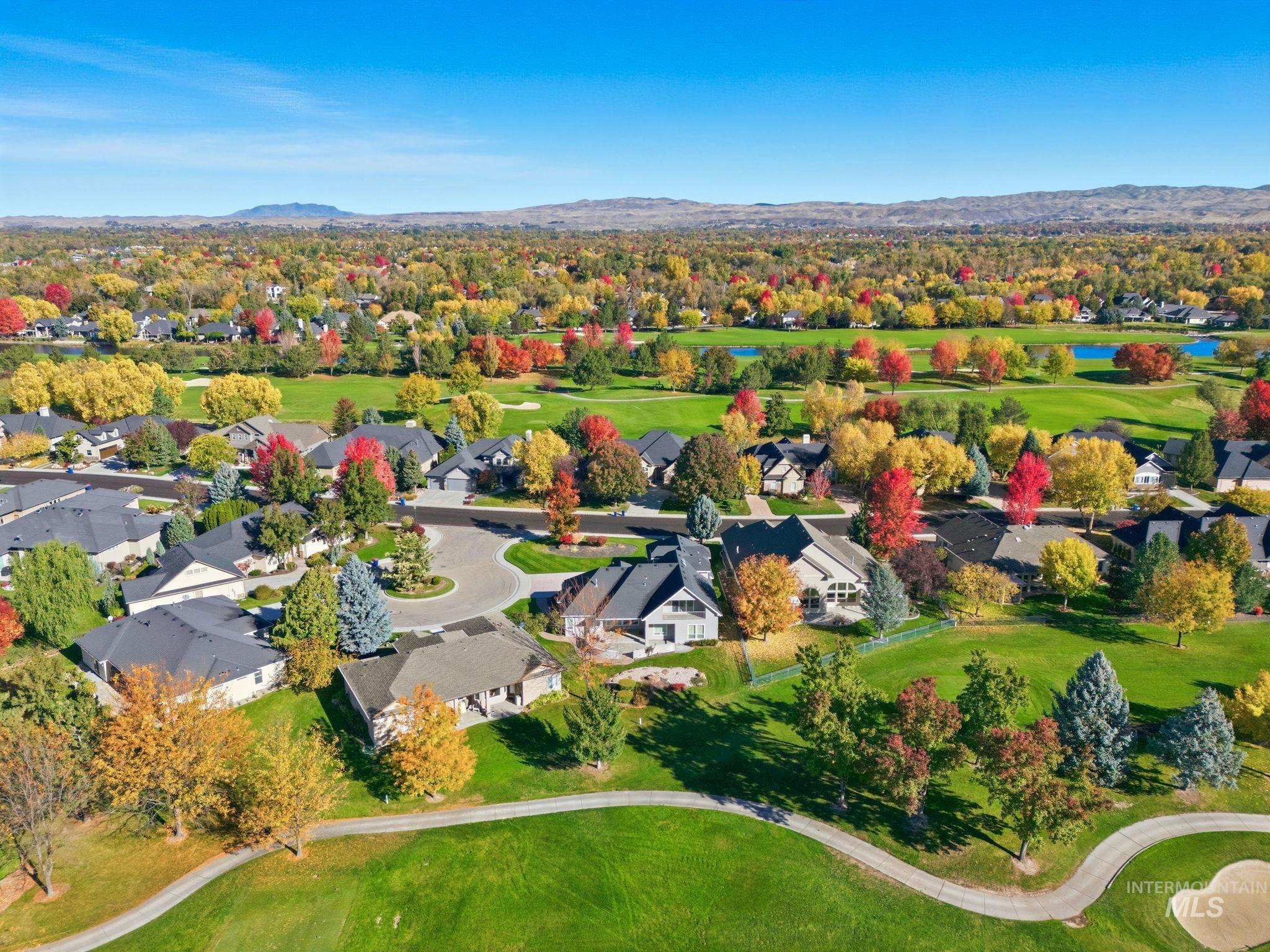 Aerial view of residential area with a local golf course and a mountain backdrop