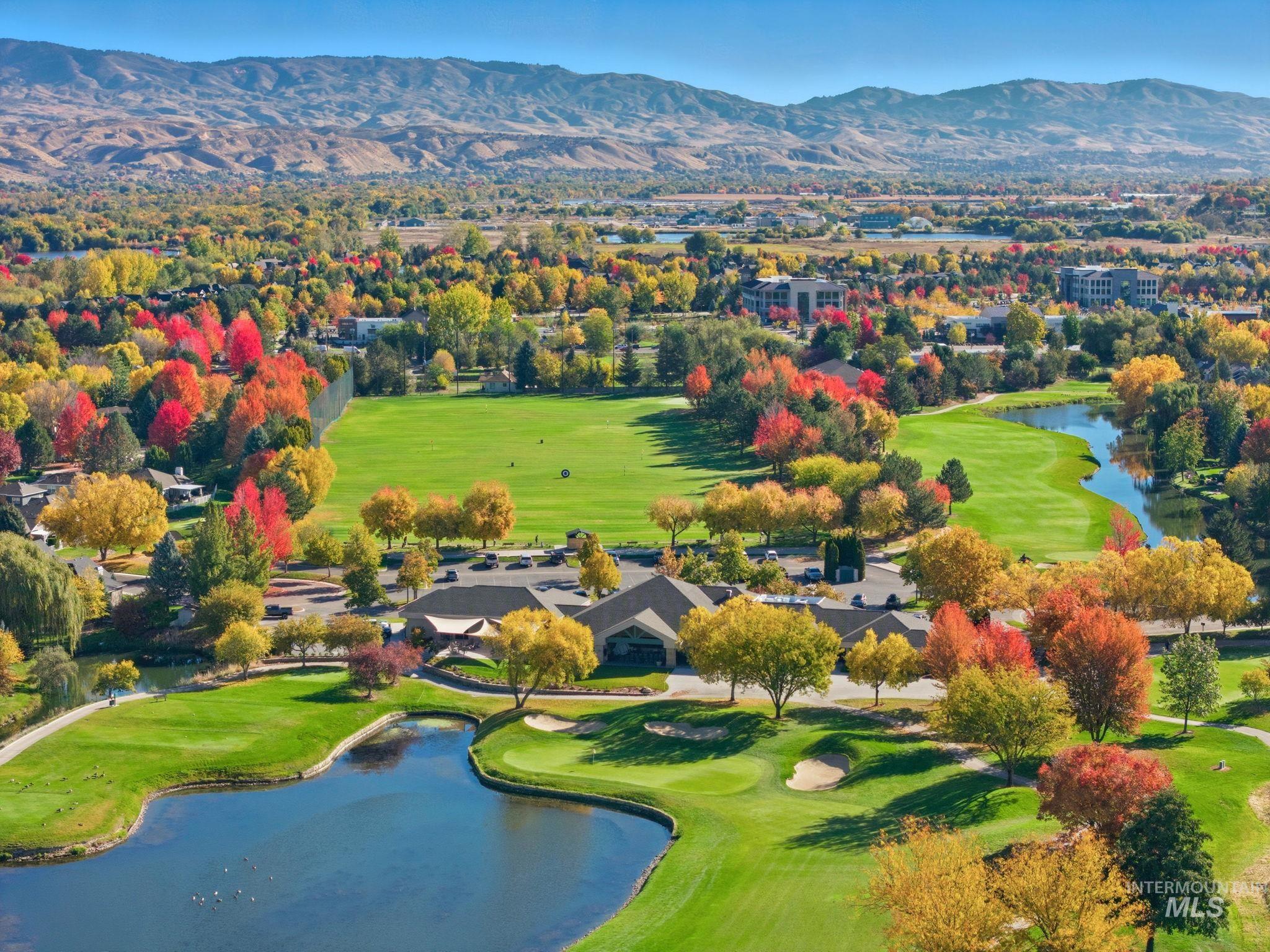 Drone / aerial view of a water and mountain view and a local golf course