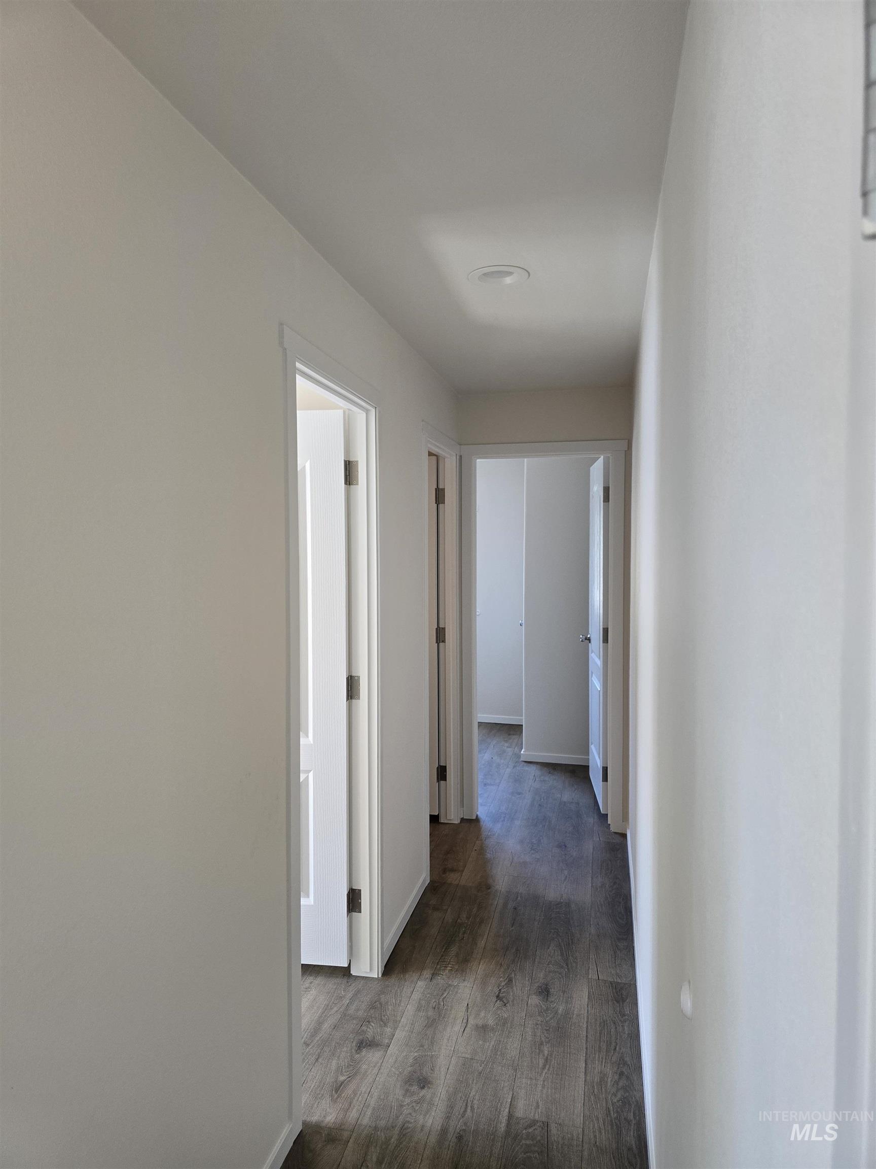 Hall featuring dark wood-type flooring and baseboards