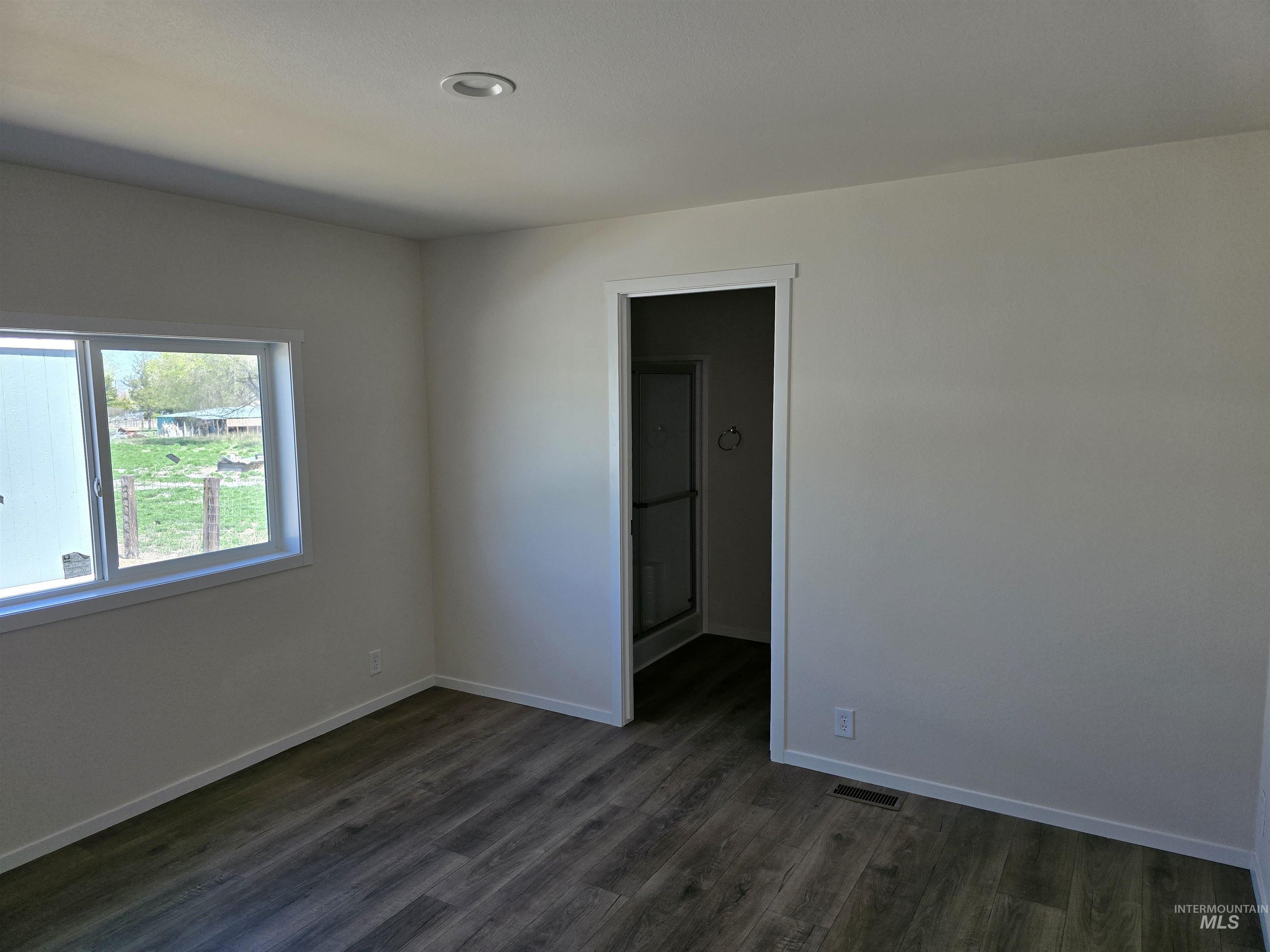 Spare room featuring dark wood-style floors and recessed lighting