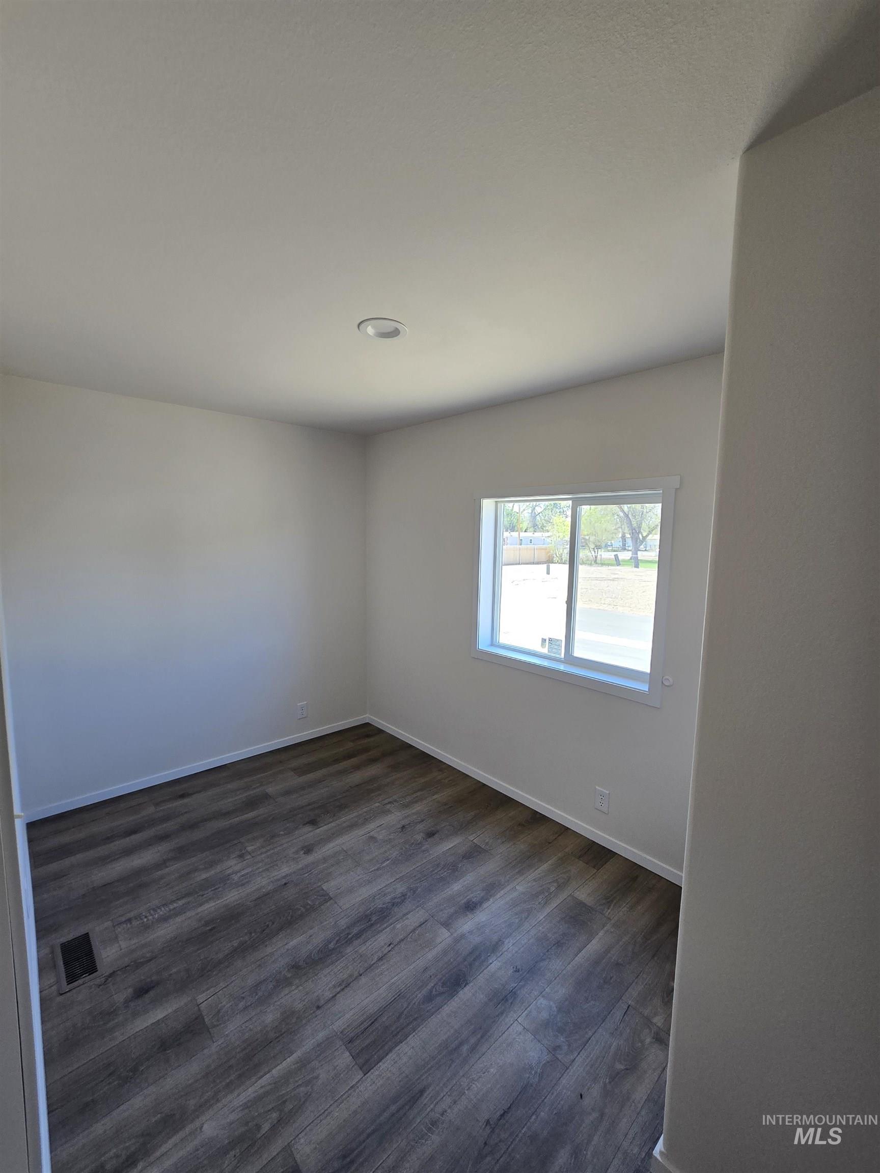 Unfurnished room featuring dark wood finished floors