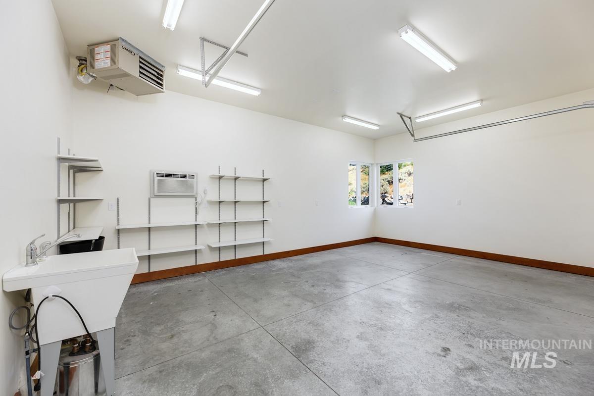 Garage with baseboards and a heating unit