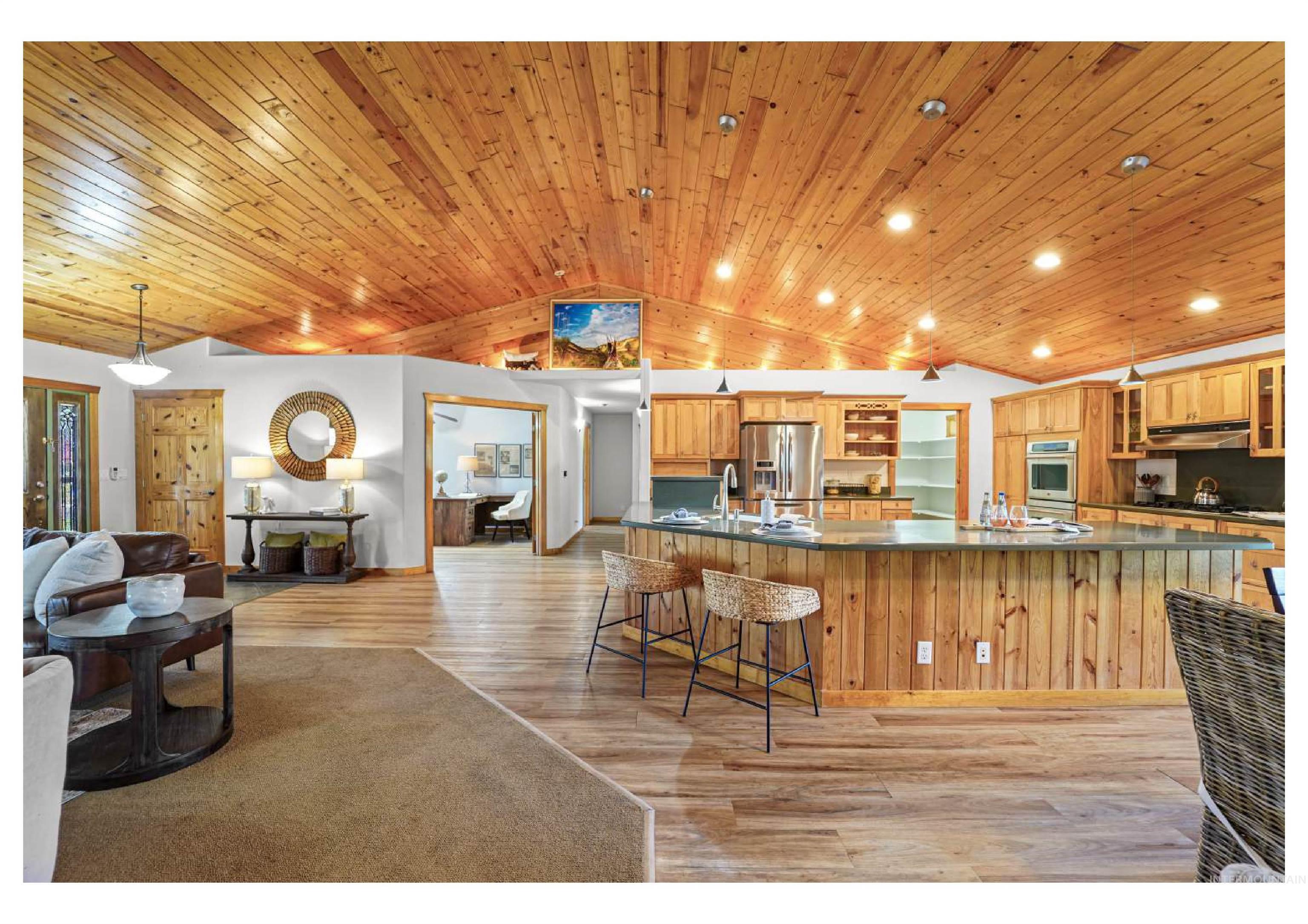 Kitchen featuring glass insert cabinets, a breakfast bar, light wood-style floors, open floor plan, and stainless steel fridge