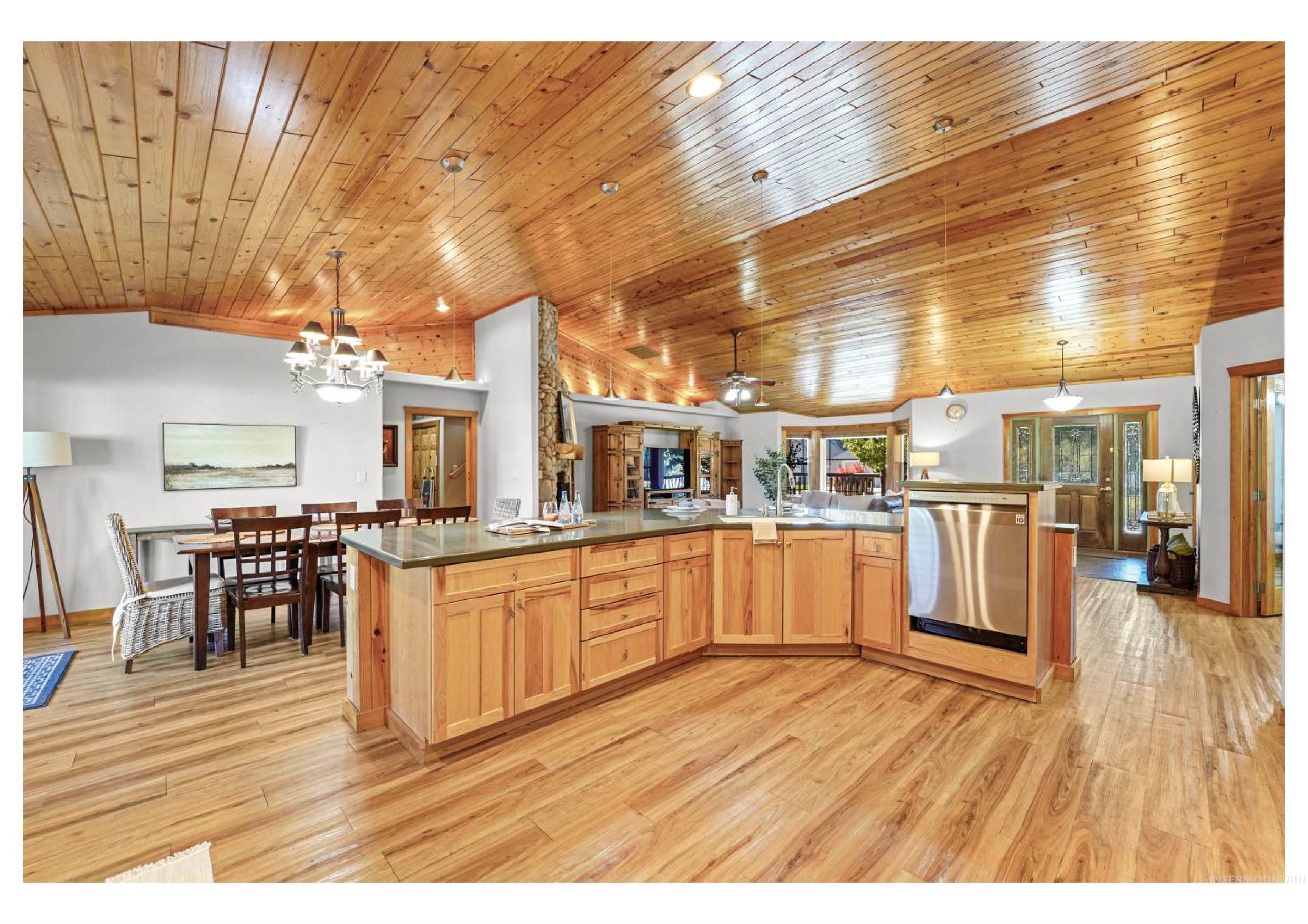 Kitchen featuring hanging light fixtures, dishwasher, open floor plan, light wood-style floors, and a chandelier