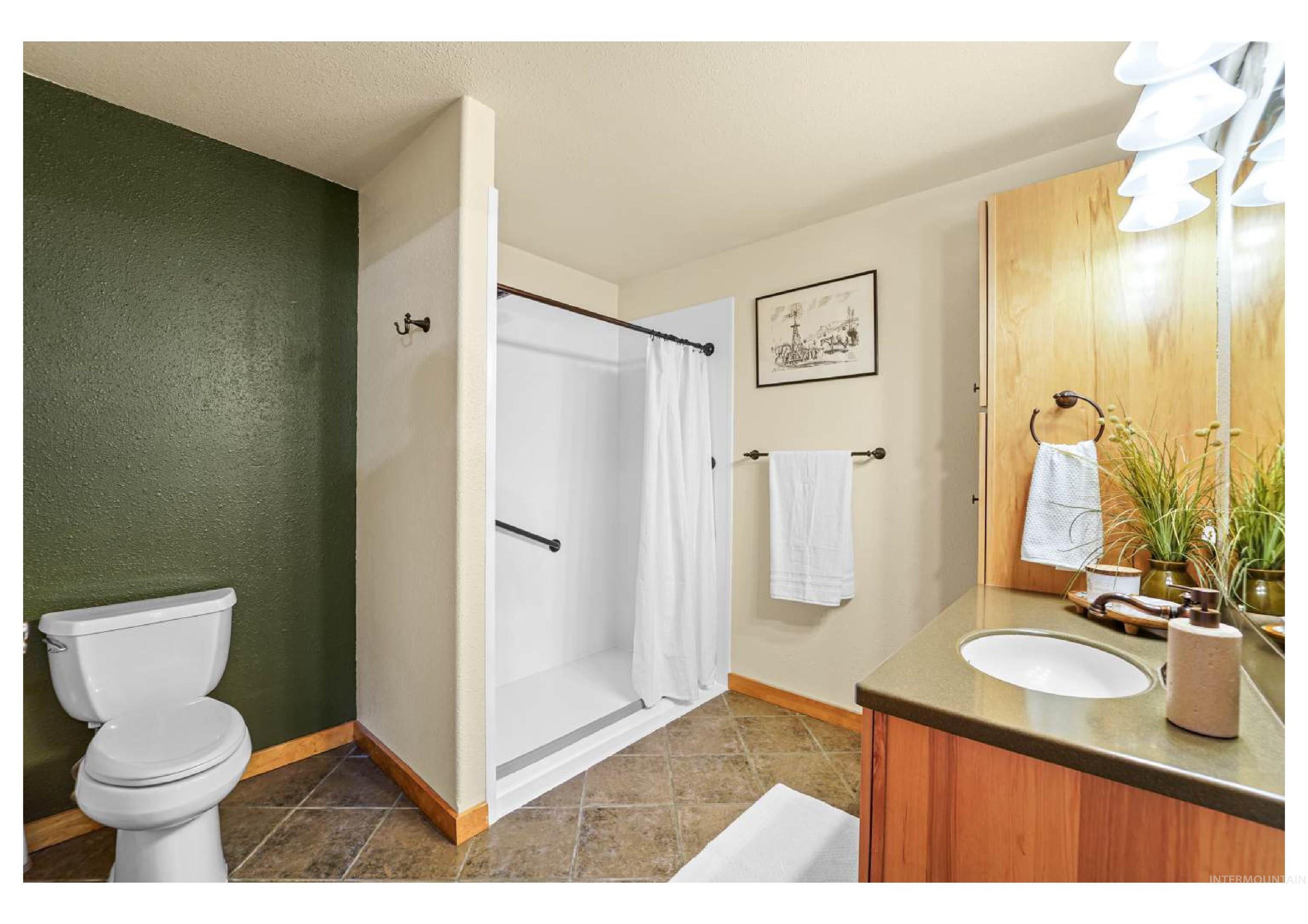 Full bathroom with vanity, a stall shower, and dark tile patterned floors
