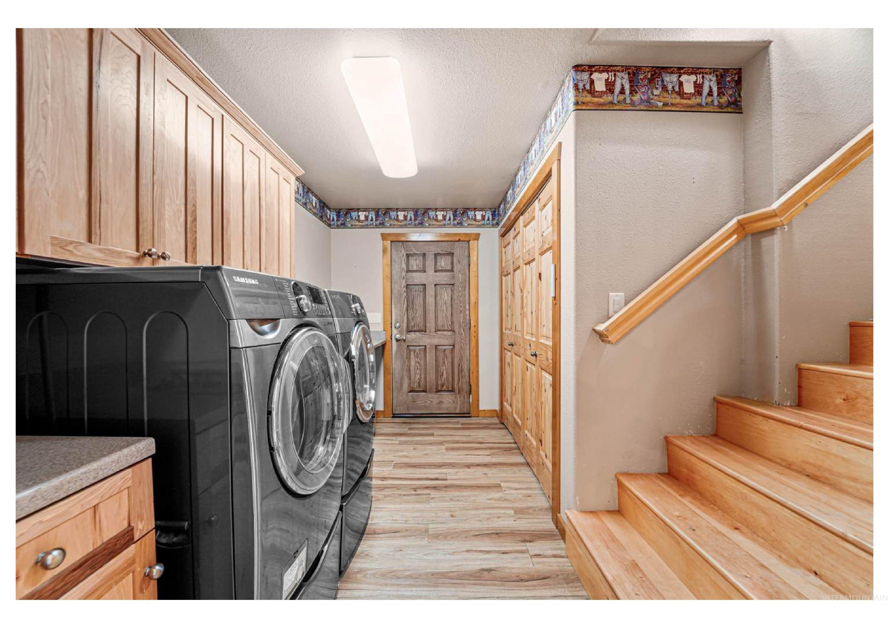 Washroom with independent washer and dryer, a textured ceiling, light wood-style flooring, and cabinet space