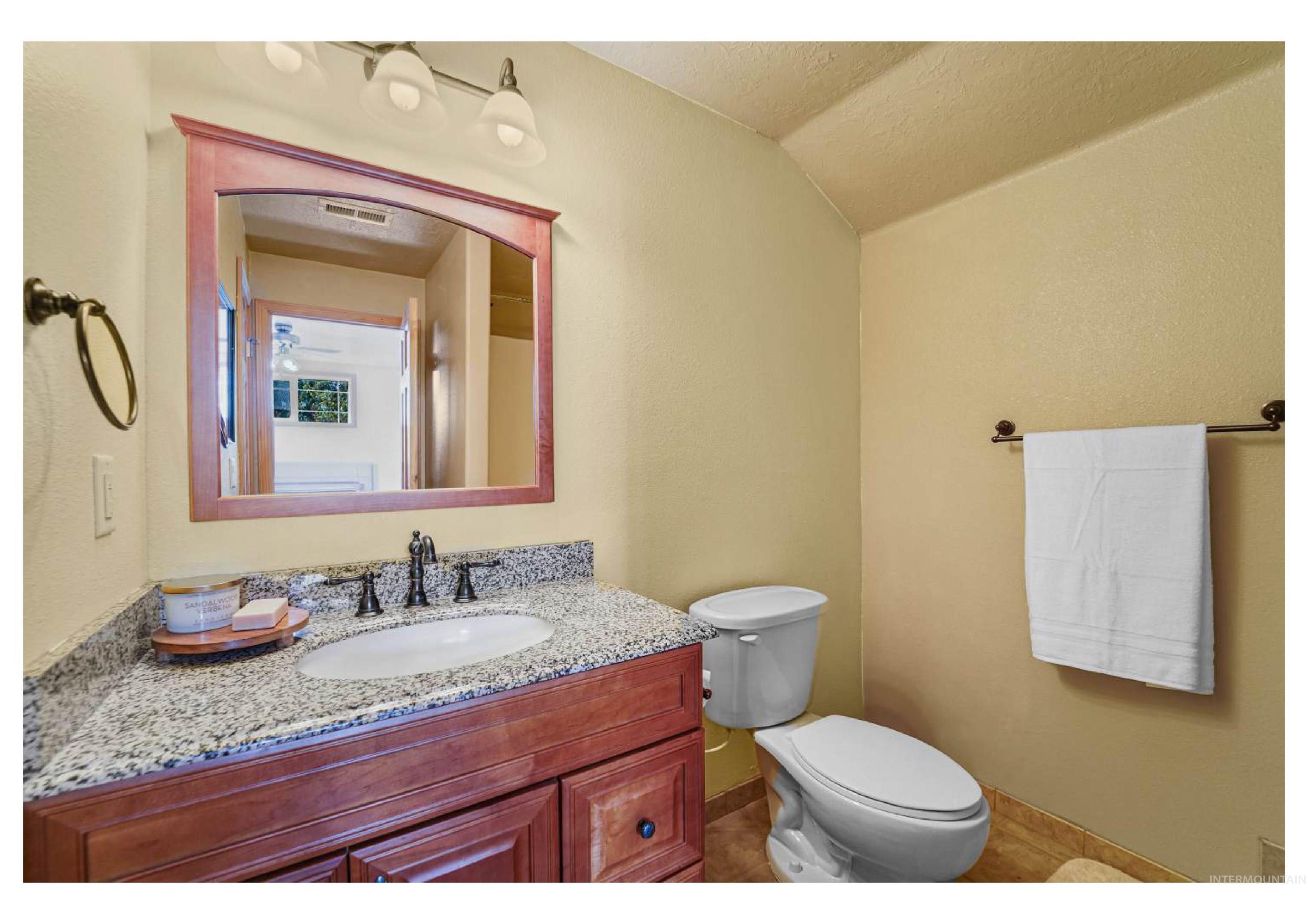 Bathroom with vanity, a textured ceiling, and a textured wall