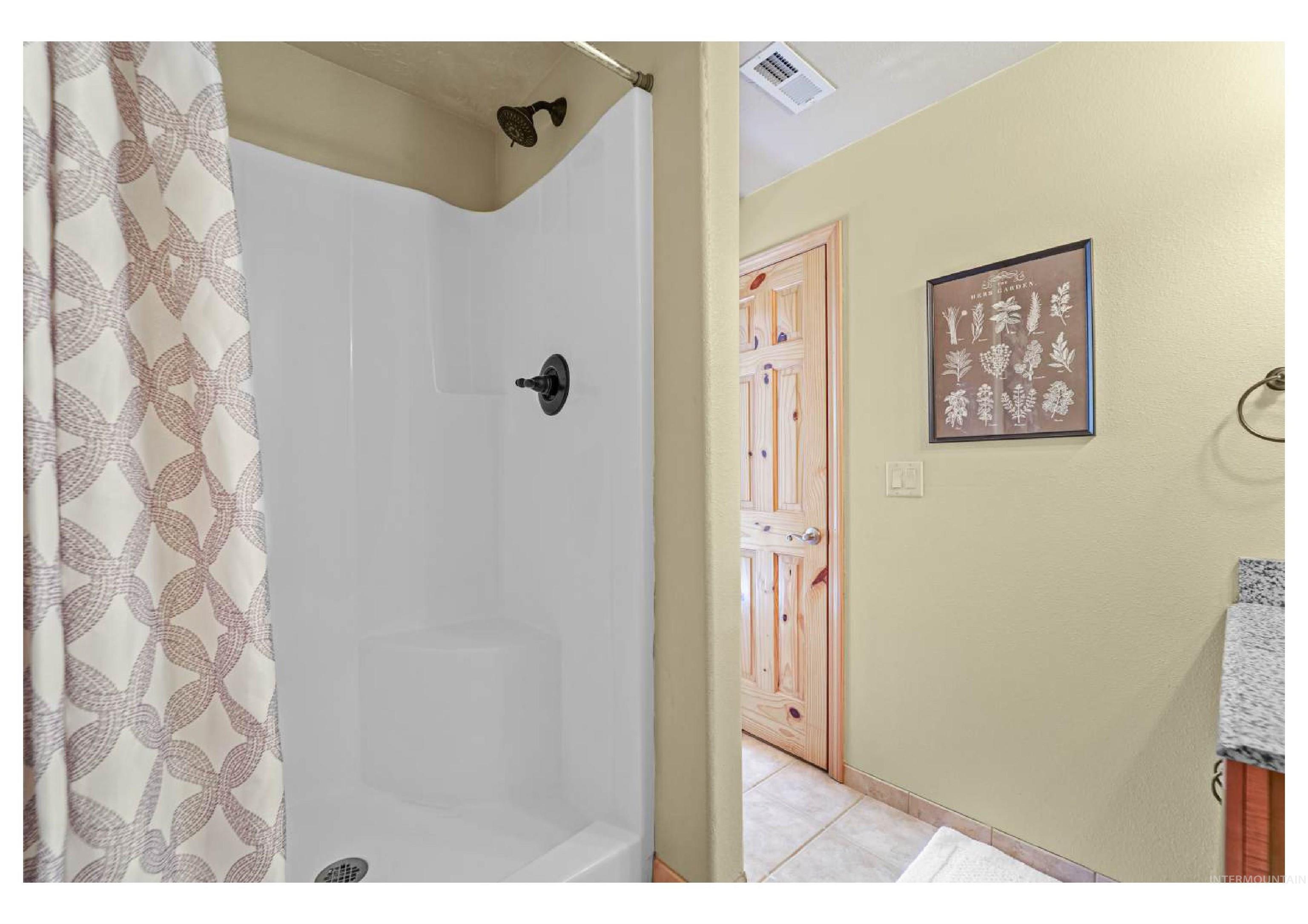 Full bath featuring light tile patterned floors, a shower with shower curtain, and vanity