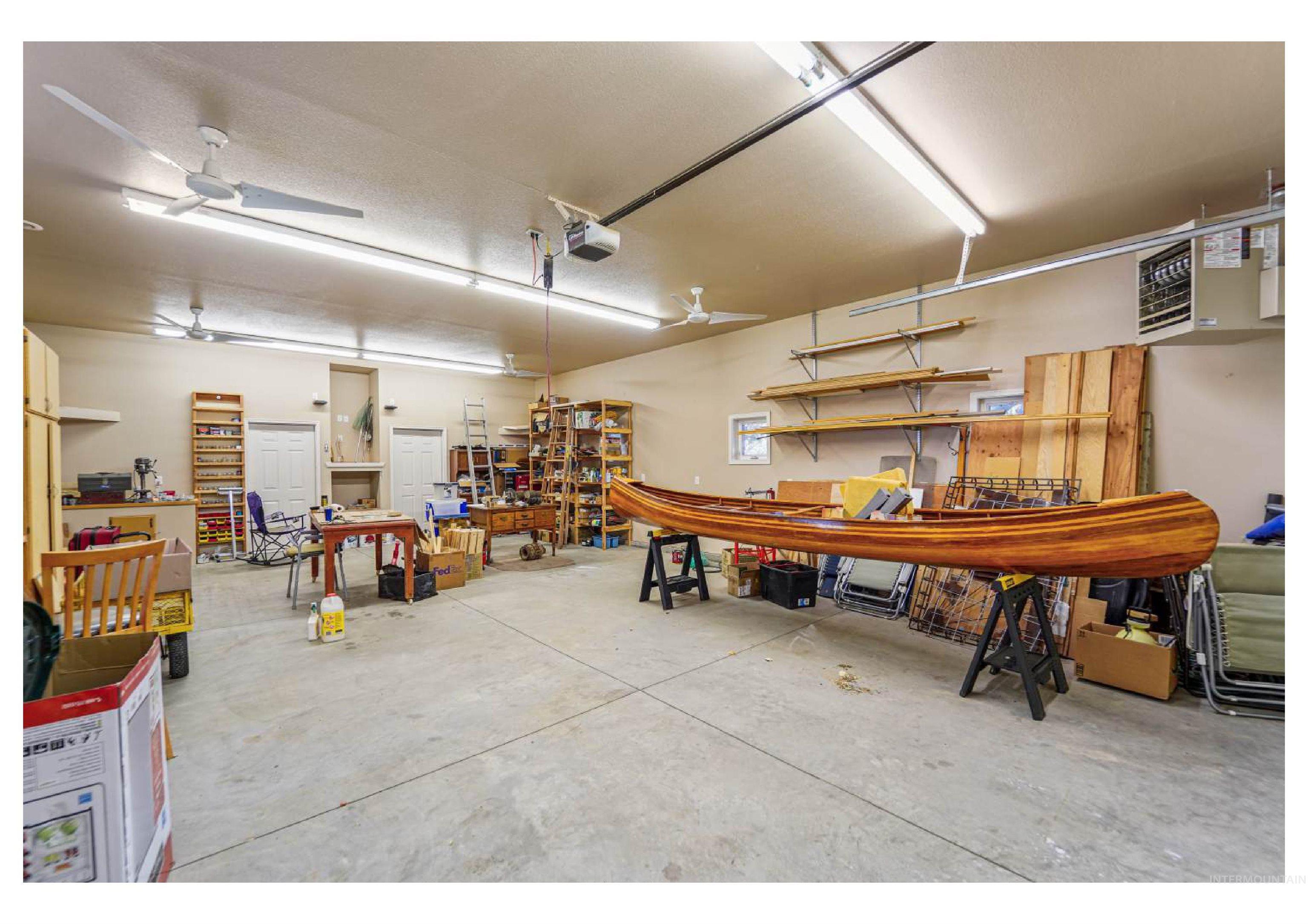 Garage featuring a workshop area, a heating unit, and a garage door opener