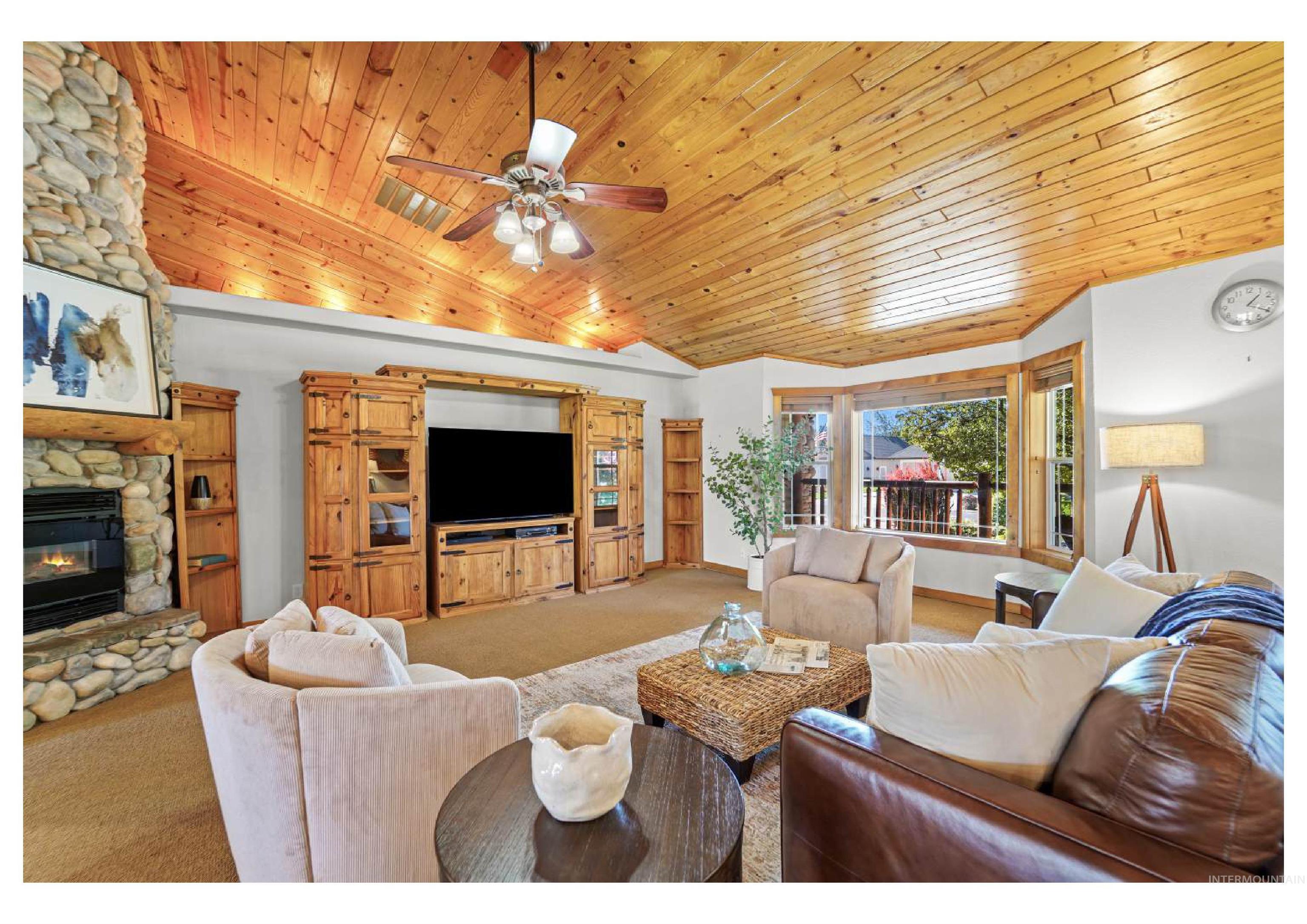 Living area with carpet, a fireplace, wood ceiling, ceiling fan, and high vaulted ceiling