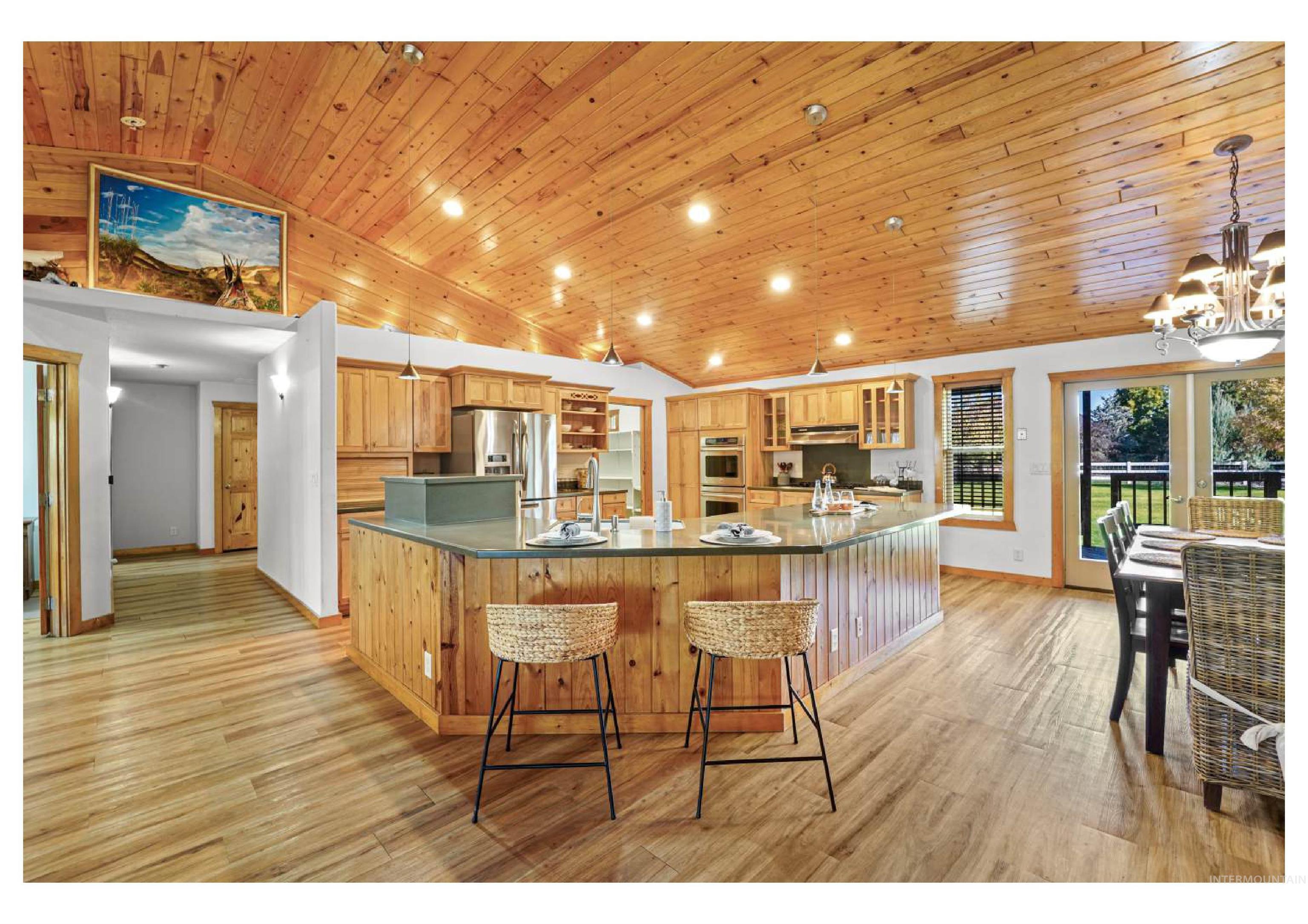 Kitchen with wooden ceiling, glass insert cabinets, decorative light fixtures, a breakfast bar, and recessed lighting