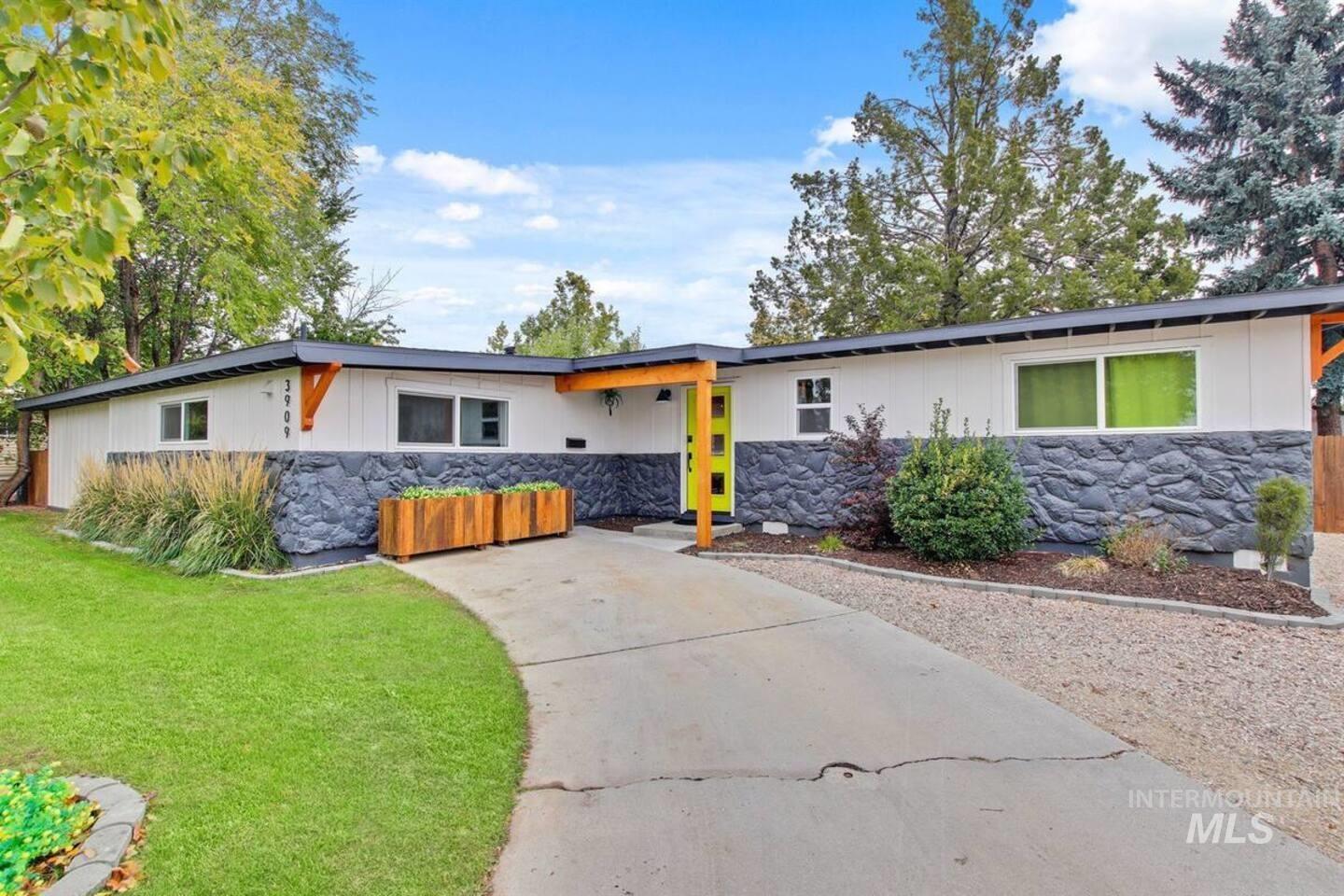 Mid-century modern home with stone siding and a front lawn