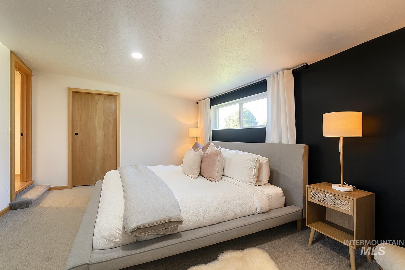 Bedroom featuring carpet flooring, a closet, and a textured ceiling