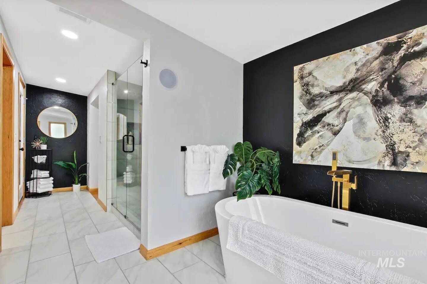 Bathroom with a soaking tub, a shower stall, and recessed lighting