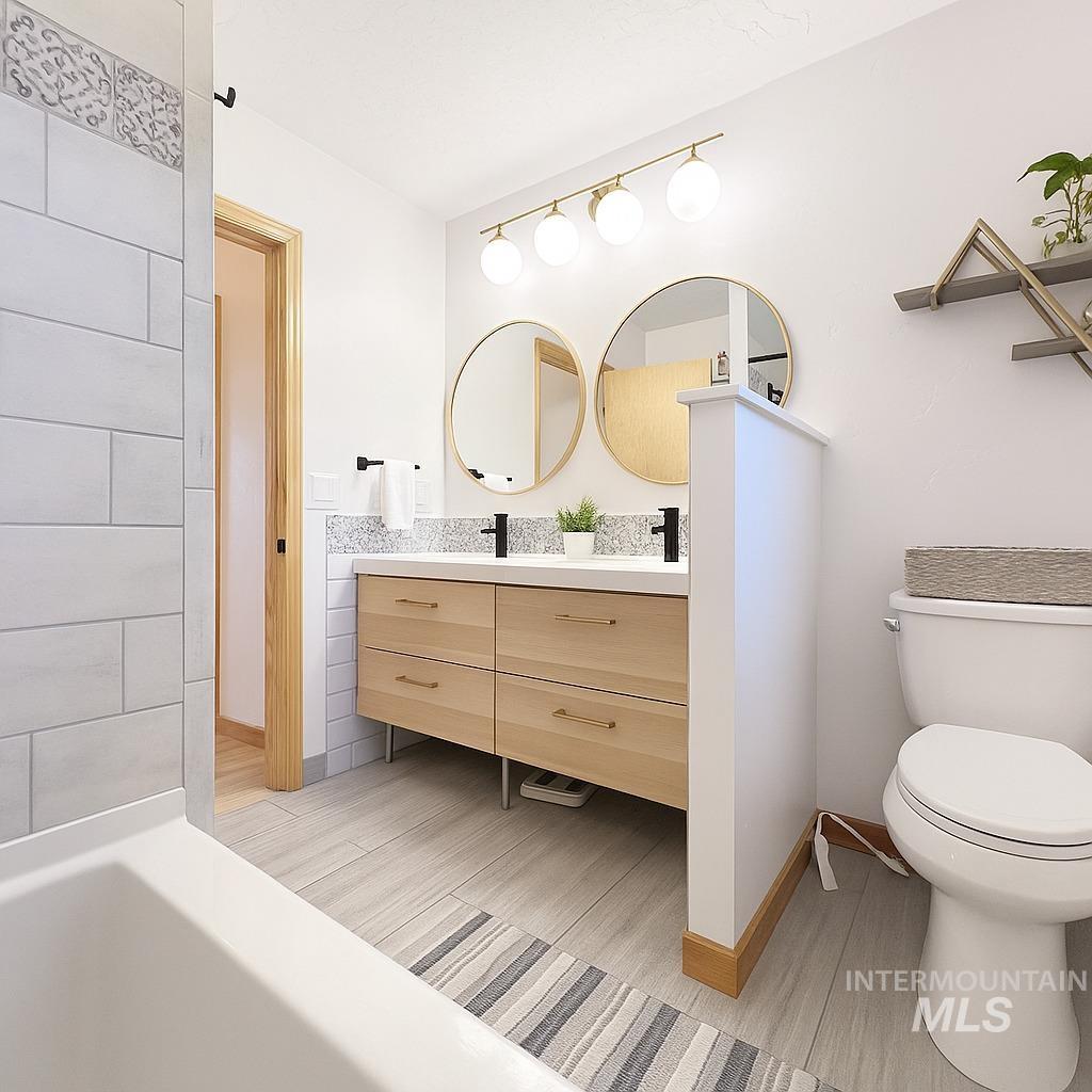 Full bathroom featuring double vanity, a tub, and light wood-style floors