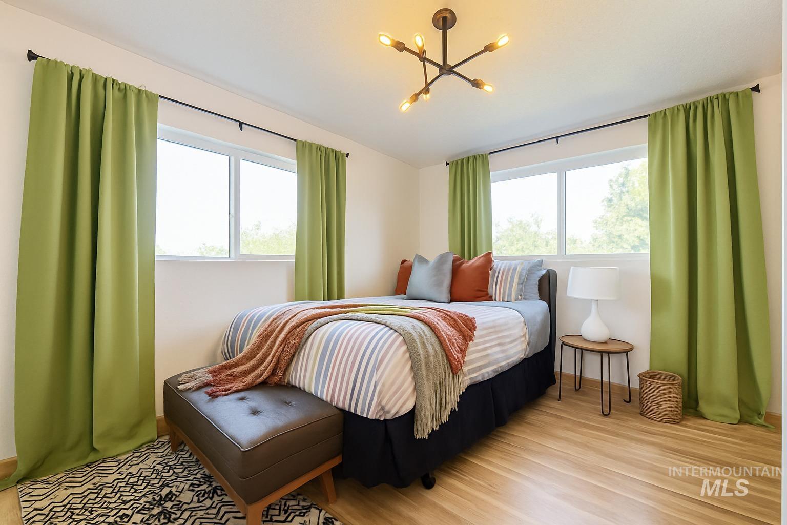 Bedroom with wood finished floors and a chandelier