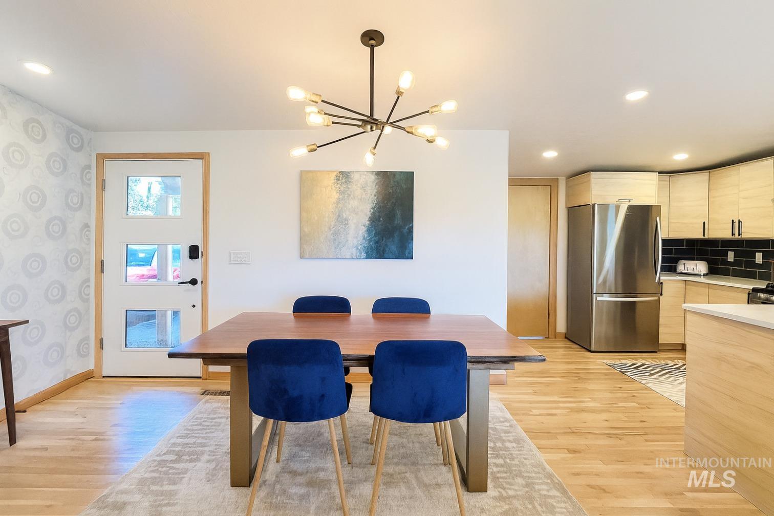 Dining room with recessed lighting, a chandelier, light wood-style flooring, and wallpapered walls