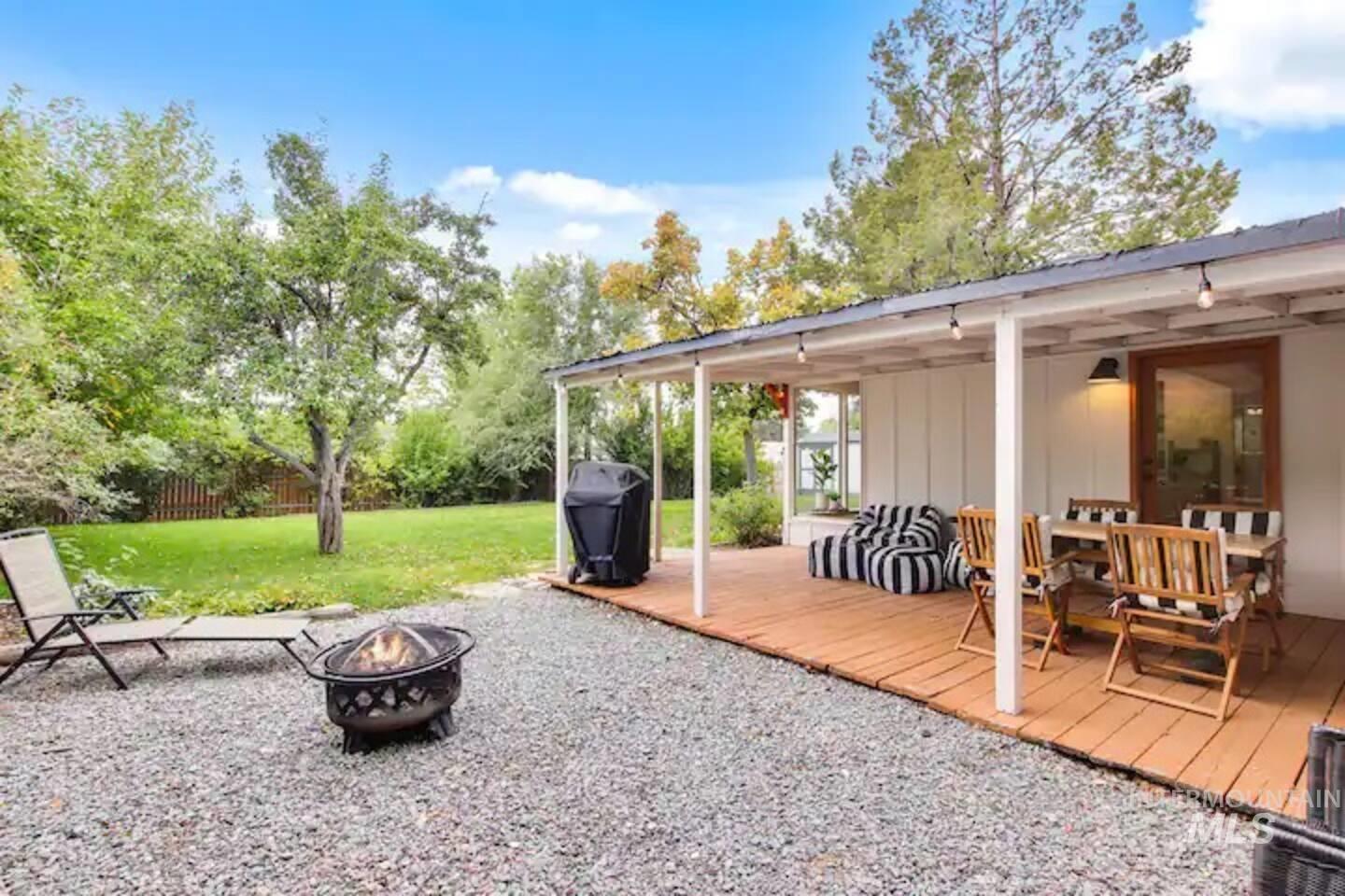 View of patio / terrace featuring a wooden deck, grilling area, and view of scattered trees