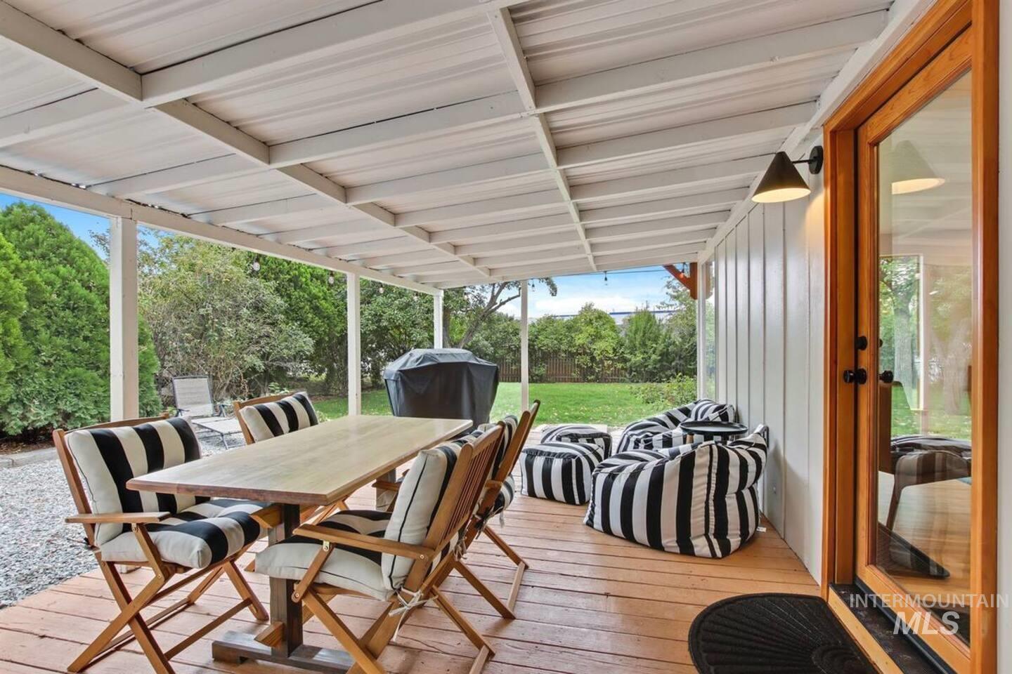 Deck with outdoor dining space, grilling area, and a yard