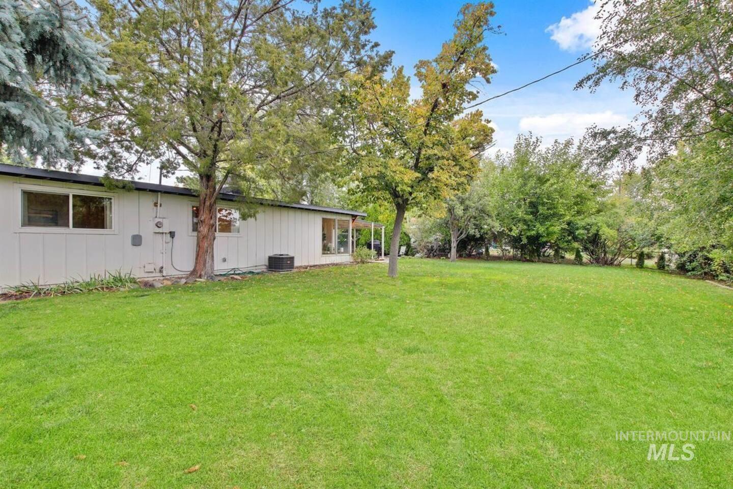 View of grassy yard featuring view of scattered trees