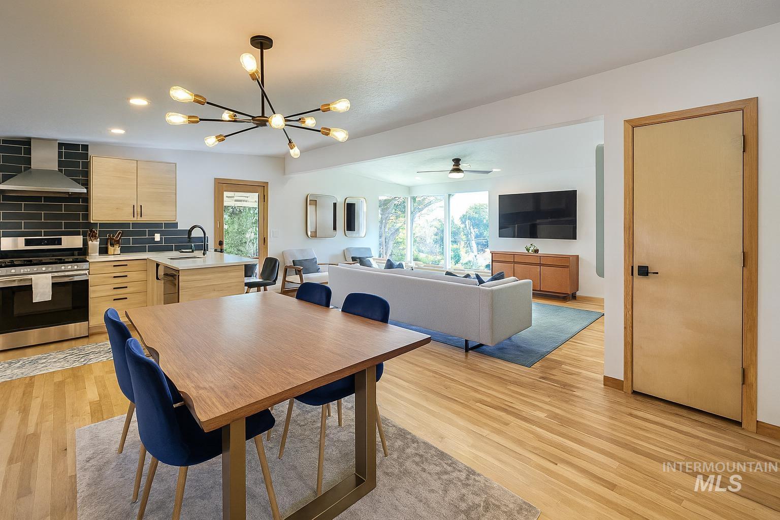 Dining room with a chandelier, light wood-type flooring, ceiling fan, and recessed lighting
