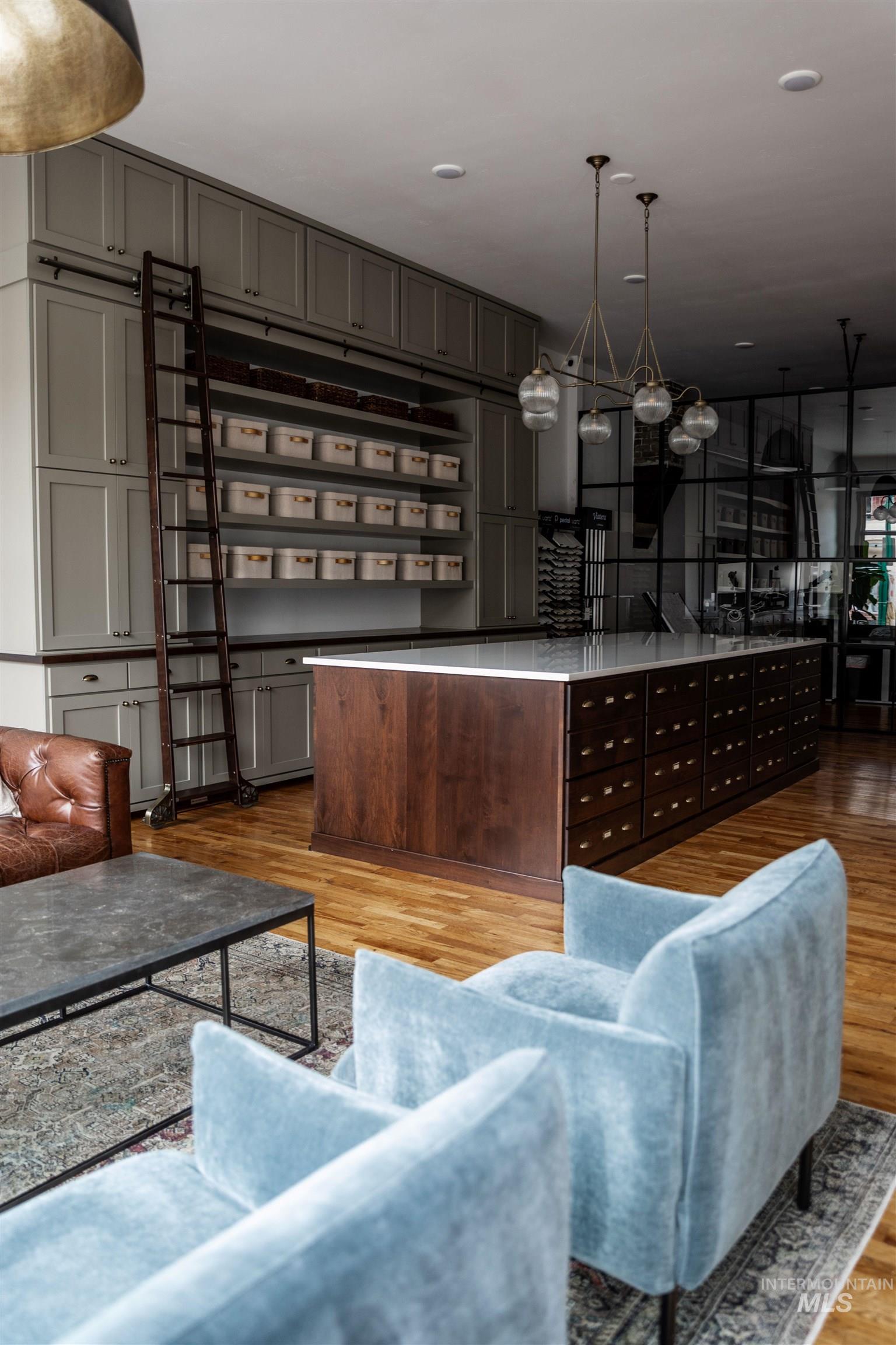 Bar area featuring pendant lighting, gray cabinetry, and light wood-type flooring