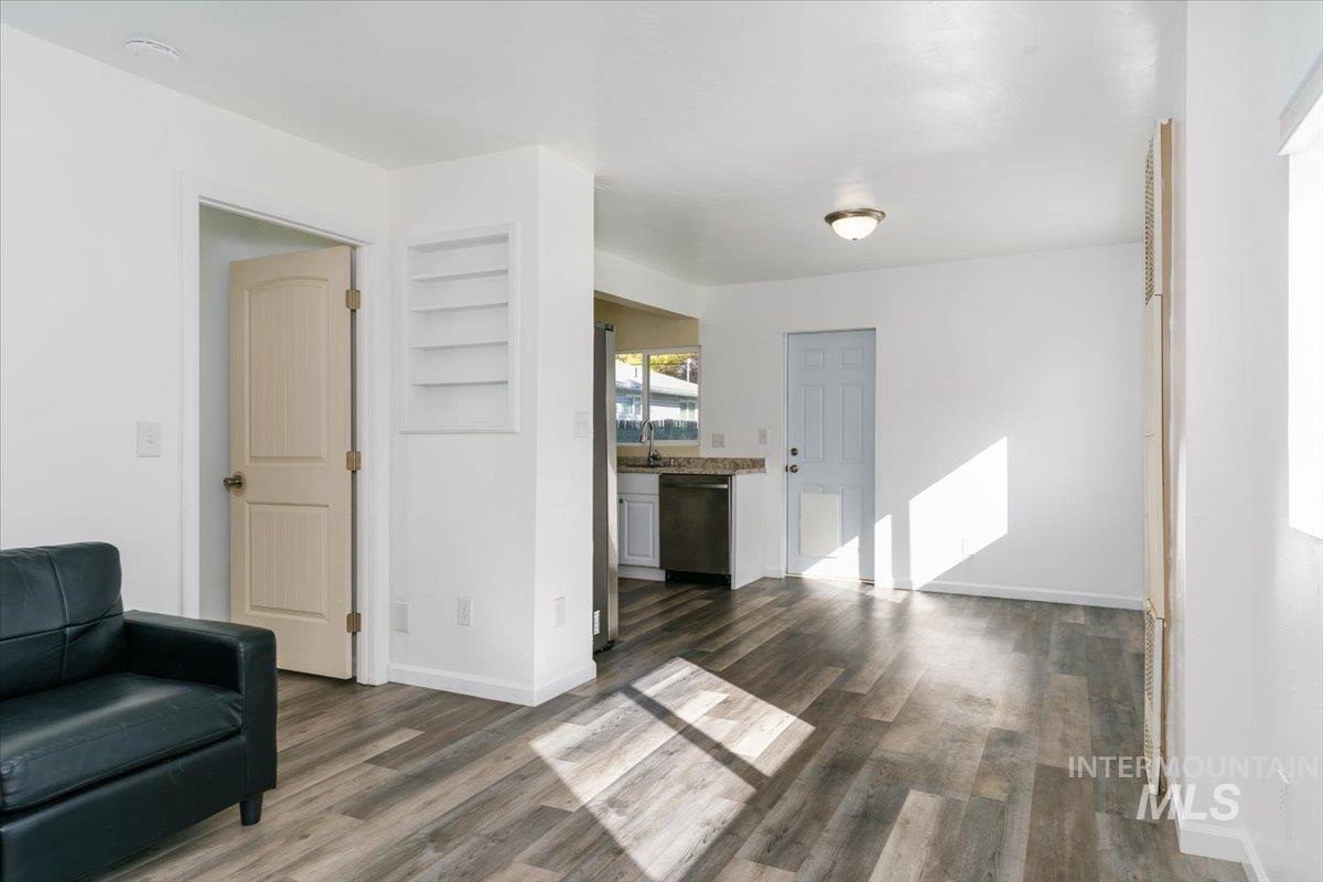 Living area with dark wood-style floors and built in features