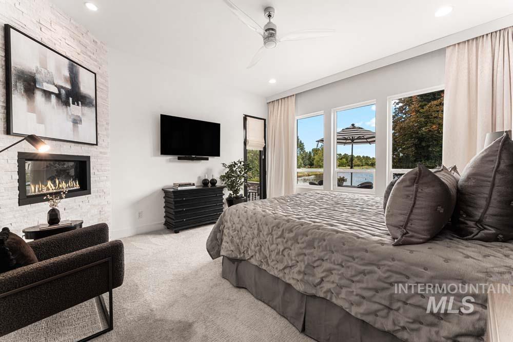 Carpeted bedroom with access to exterior, a fireplace, recessed lighting, and ceiling fan