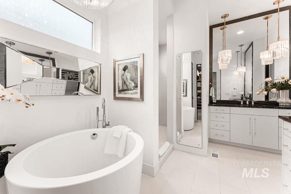 Bathroom with a freestanding tub, vanity, a stall shower, and a chandelier