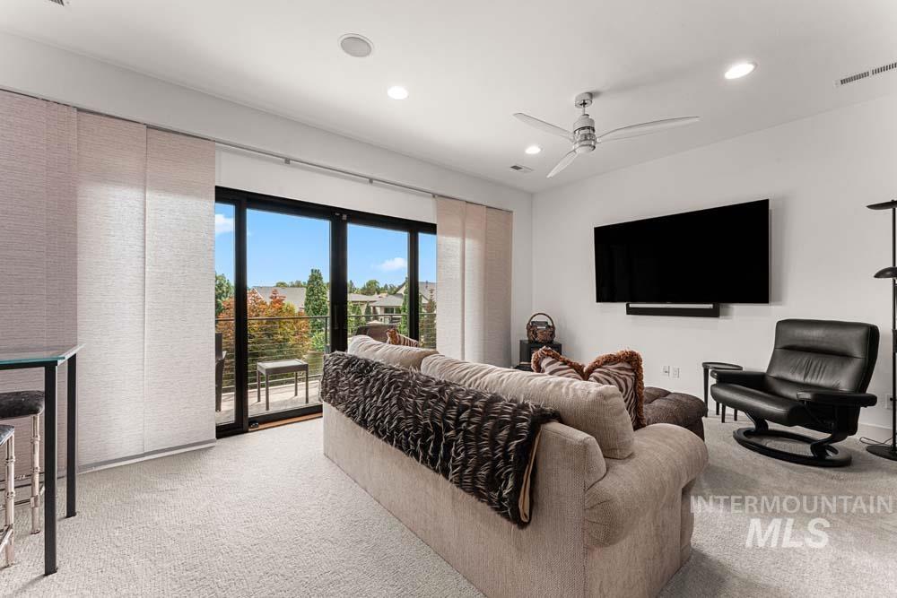 Living area with light colored carpet, recessed lighting, and a ceiling fan