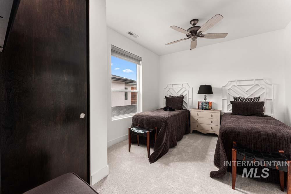 Bedroom with light carpet and a ceiling fan