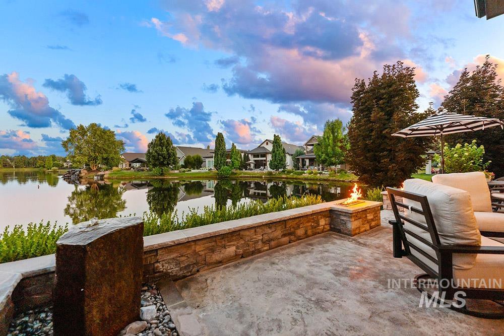 View of patio / terrace featuring an outdoor fire pit, a water view, and a residential view