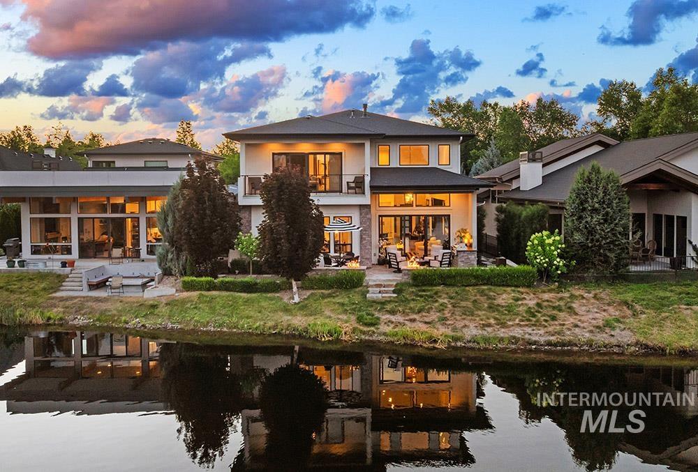 Back of property at dusk with a balcony and a patio