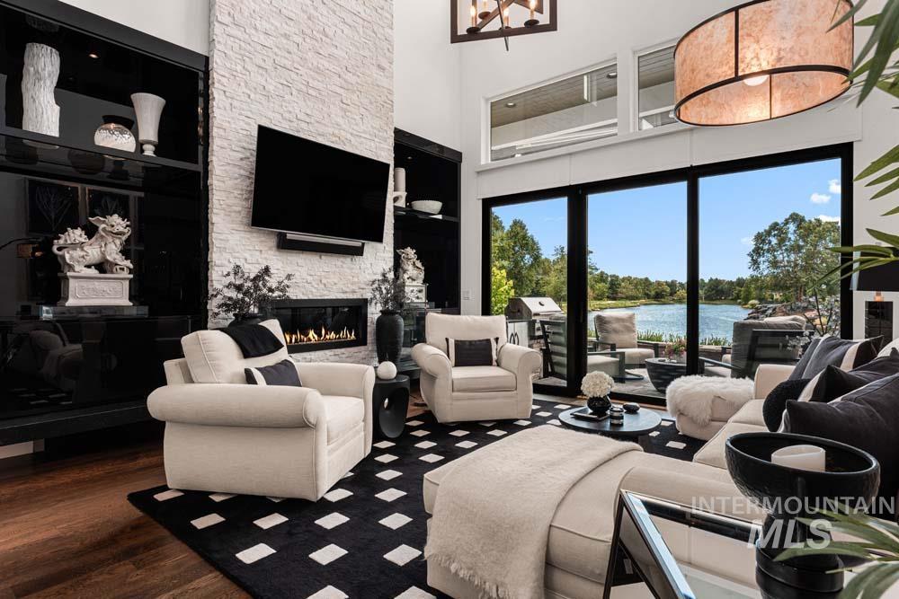 Living room with a high ceiling, a fireplace, and wood finished floors