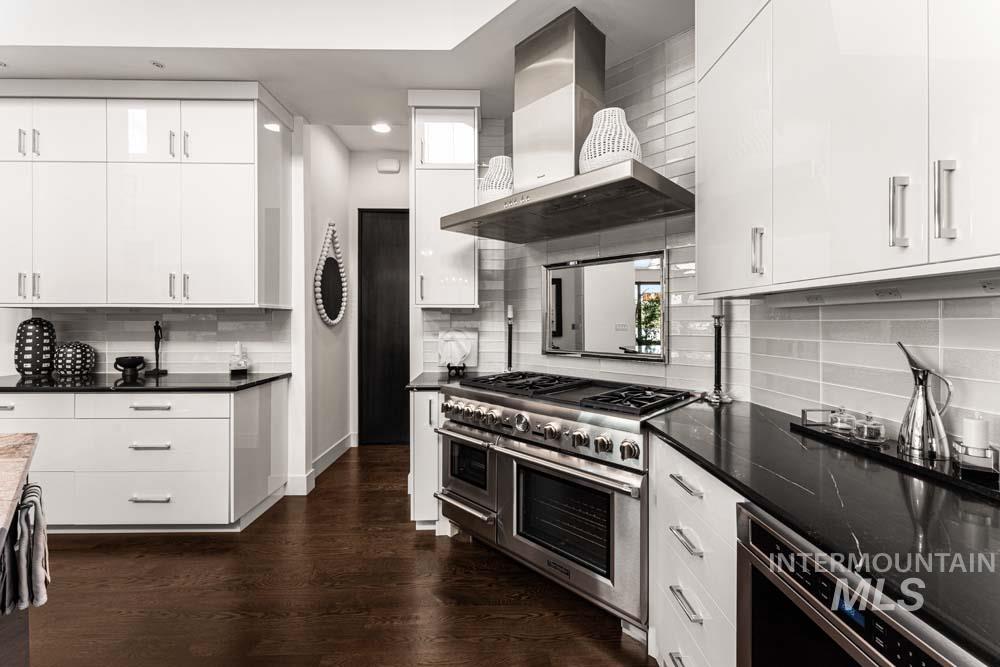 Kitchen with wall chimney range hood, decorative backsplash, double oven range, dark wood-style flooring, and recessed lighting