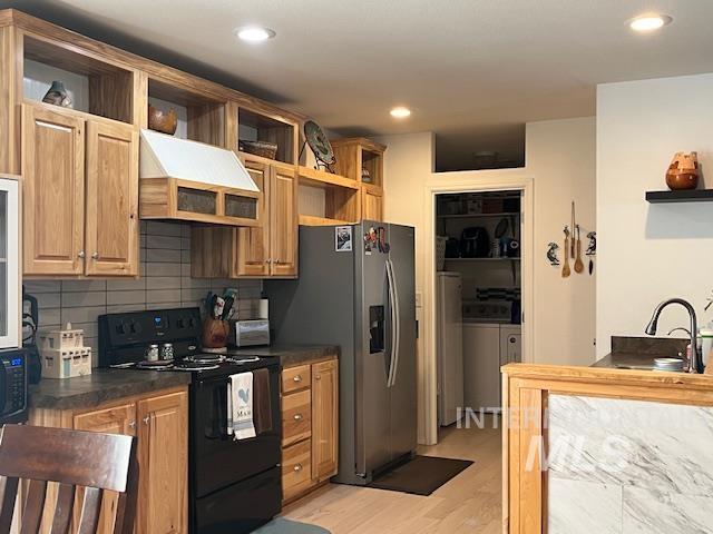Kitchen featuring open shelves, black appliances, dark countertops, tasteful backsplash, and custom exhaust hood