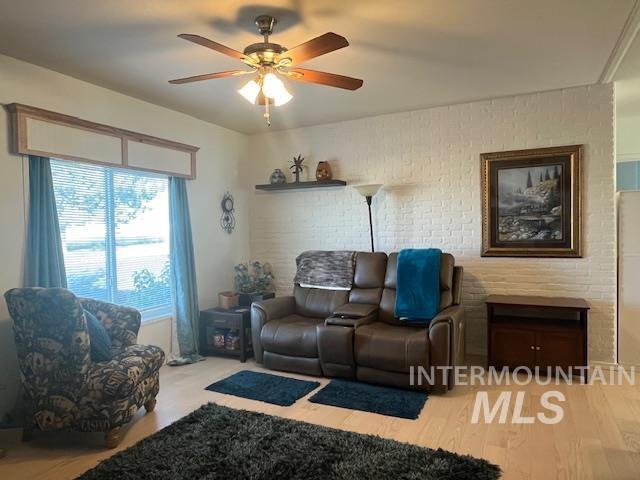 Living room featuring ceiling fan and light wood-style floors