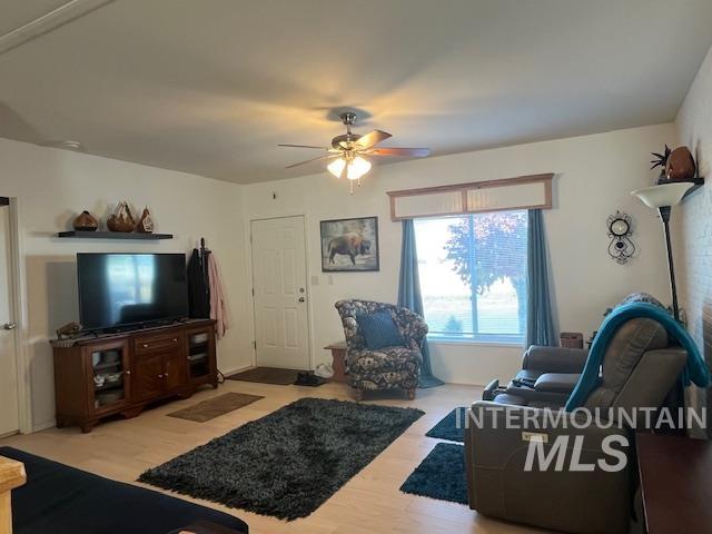 Living area with light wood-type flooring and a ceiling fan