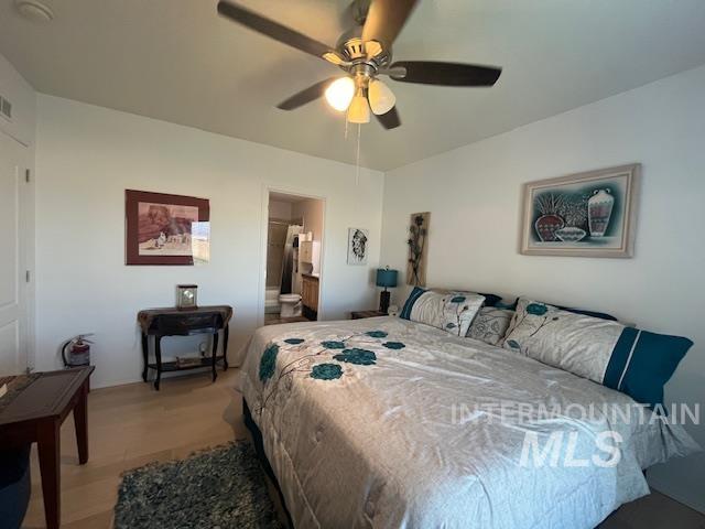 Bedroom featuring ceiling fan, connected bathroom, and wood finished floors