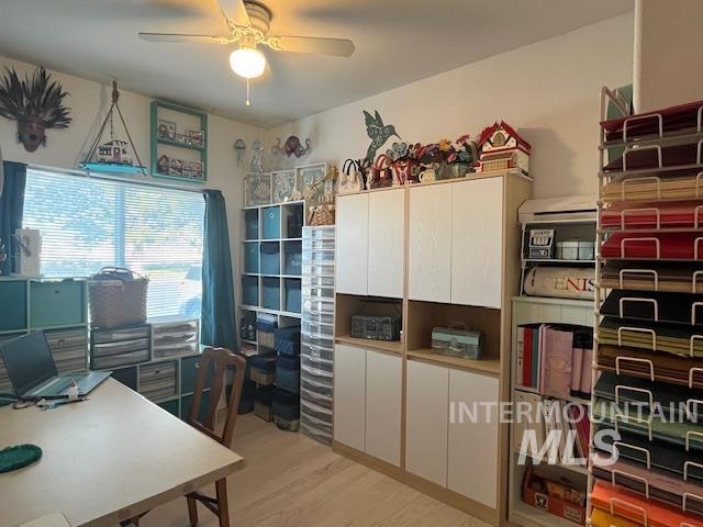 Office space with light wood finished floors and a ceiling fan